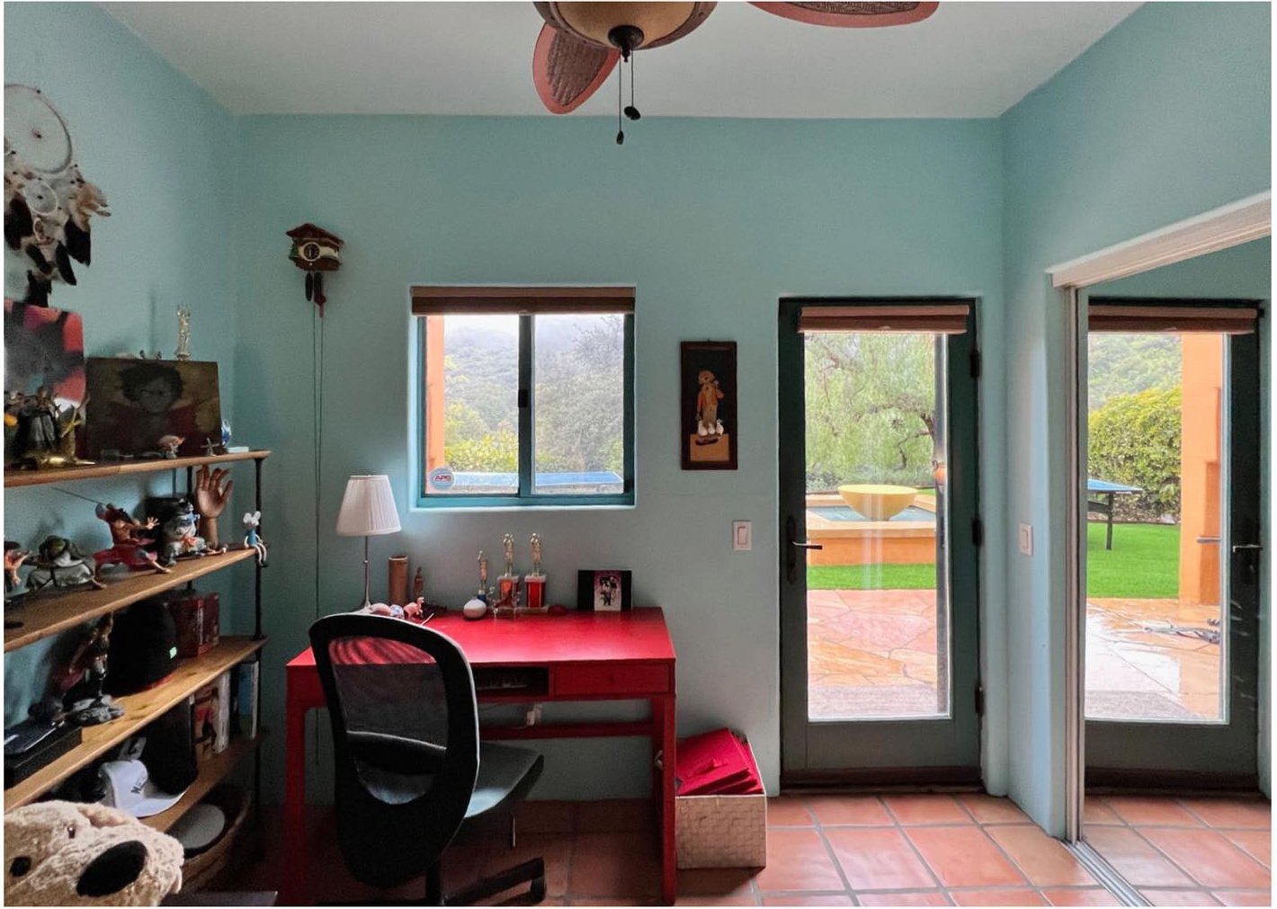 Original turquoise bedroom with desk open shelves and glazed garden doors