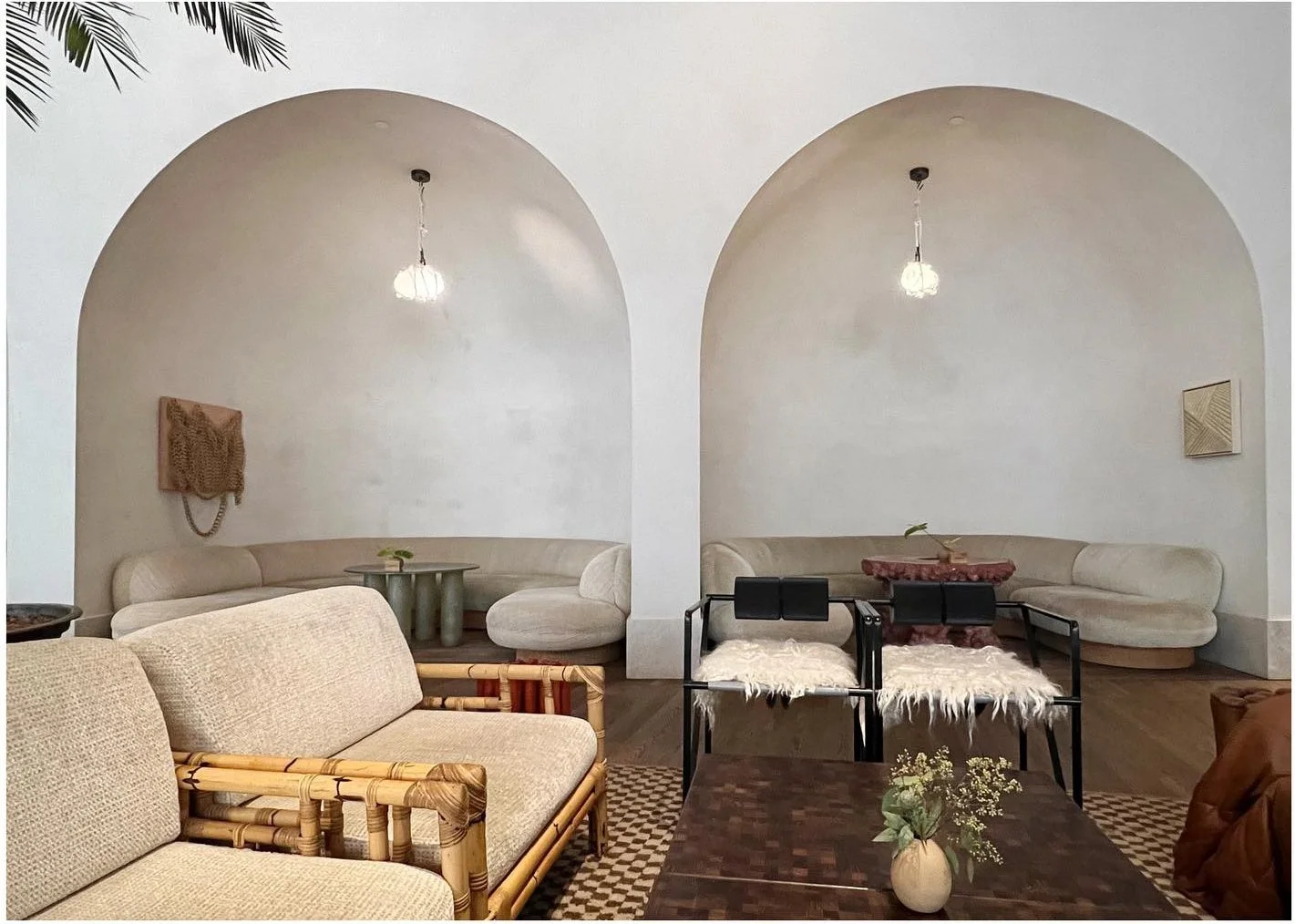 Curved pale sofas set inside tall arched wall niches