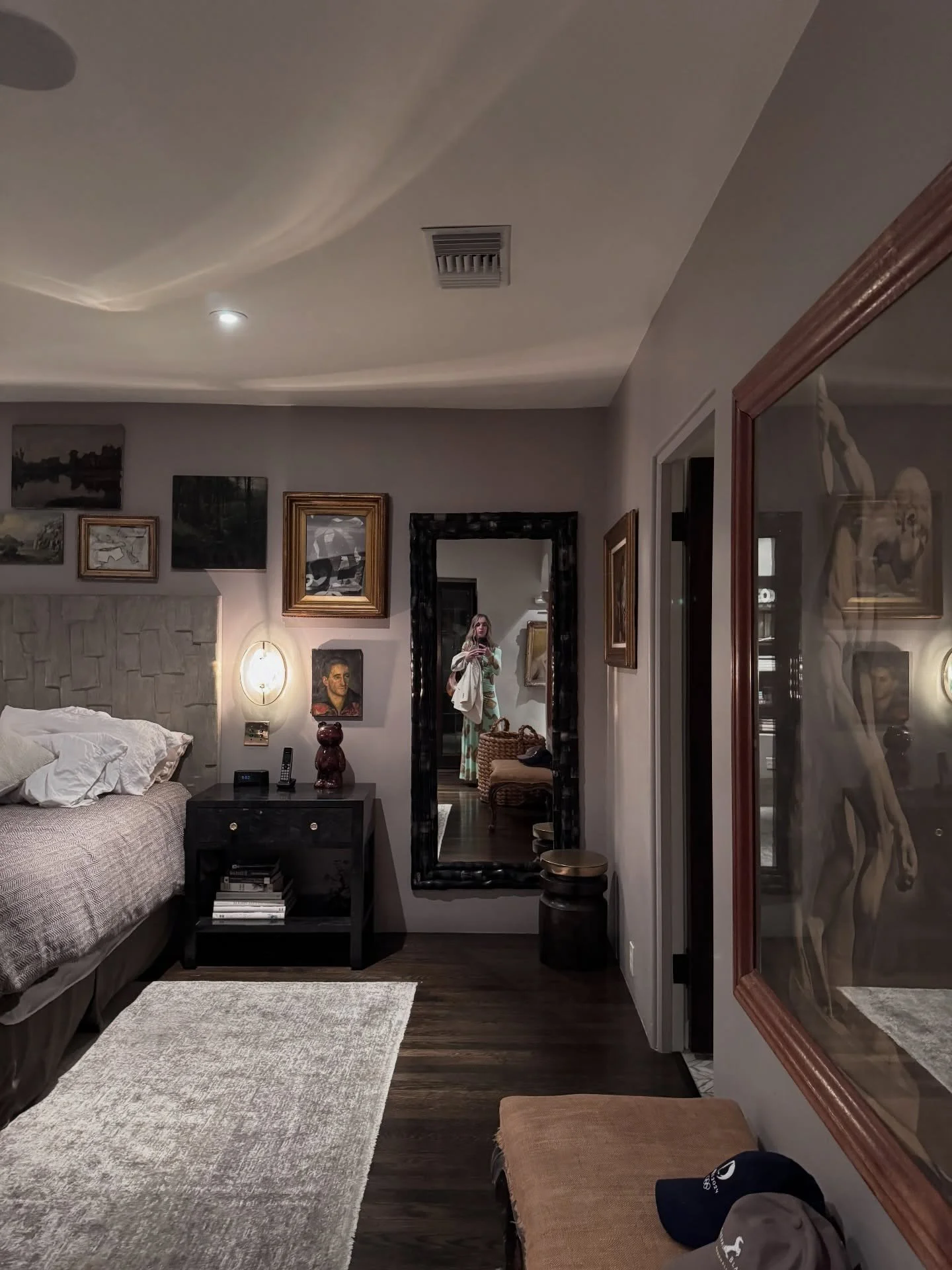 Bedroom with framed artwork and a dark wood nightstand