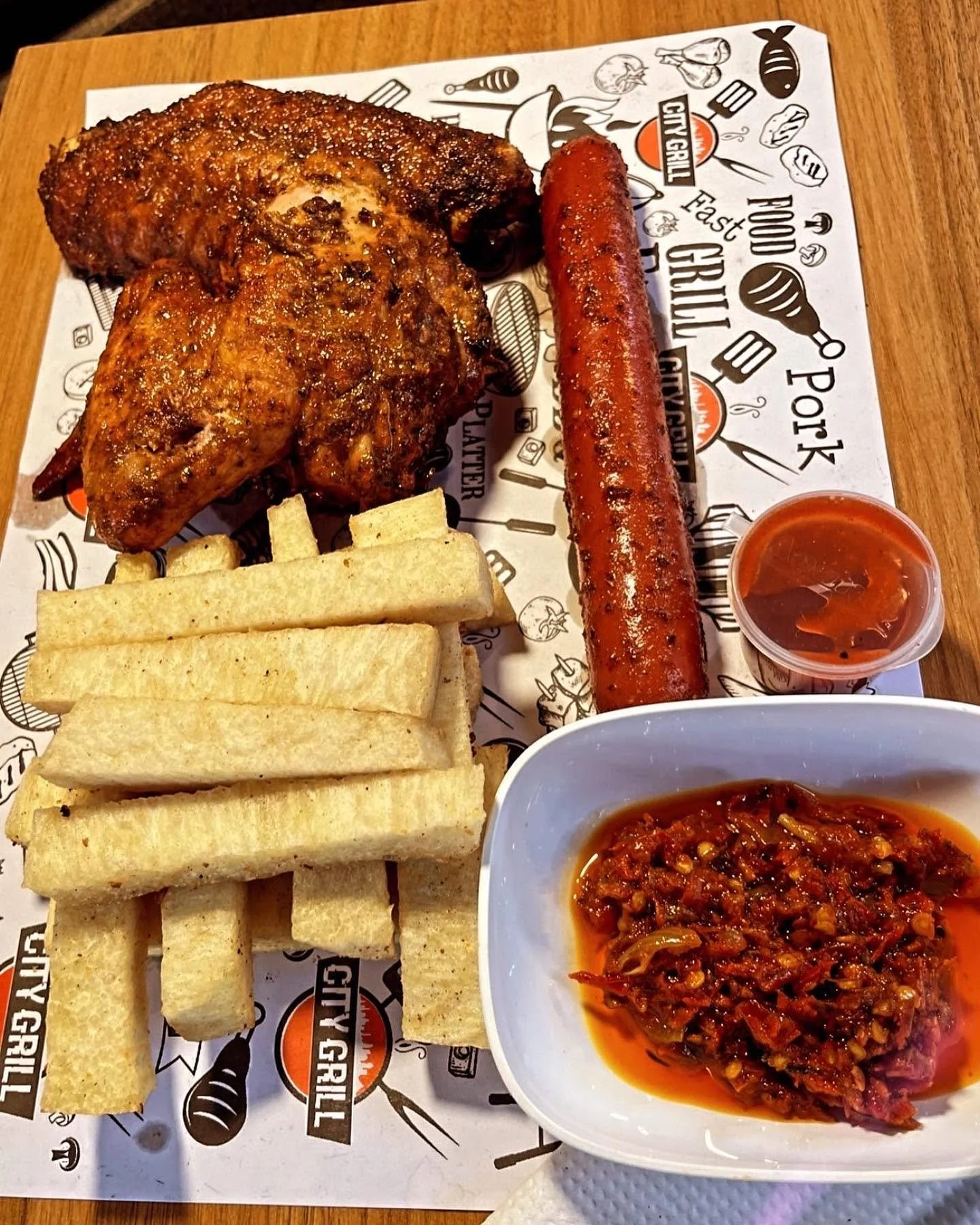 Grilled chicken, sausage, breadsticks, and spicy dipping sauces served on a platter