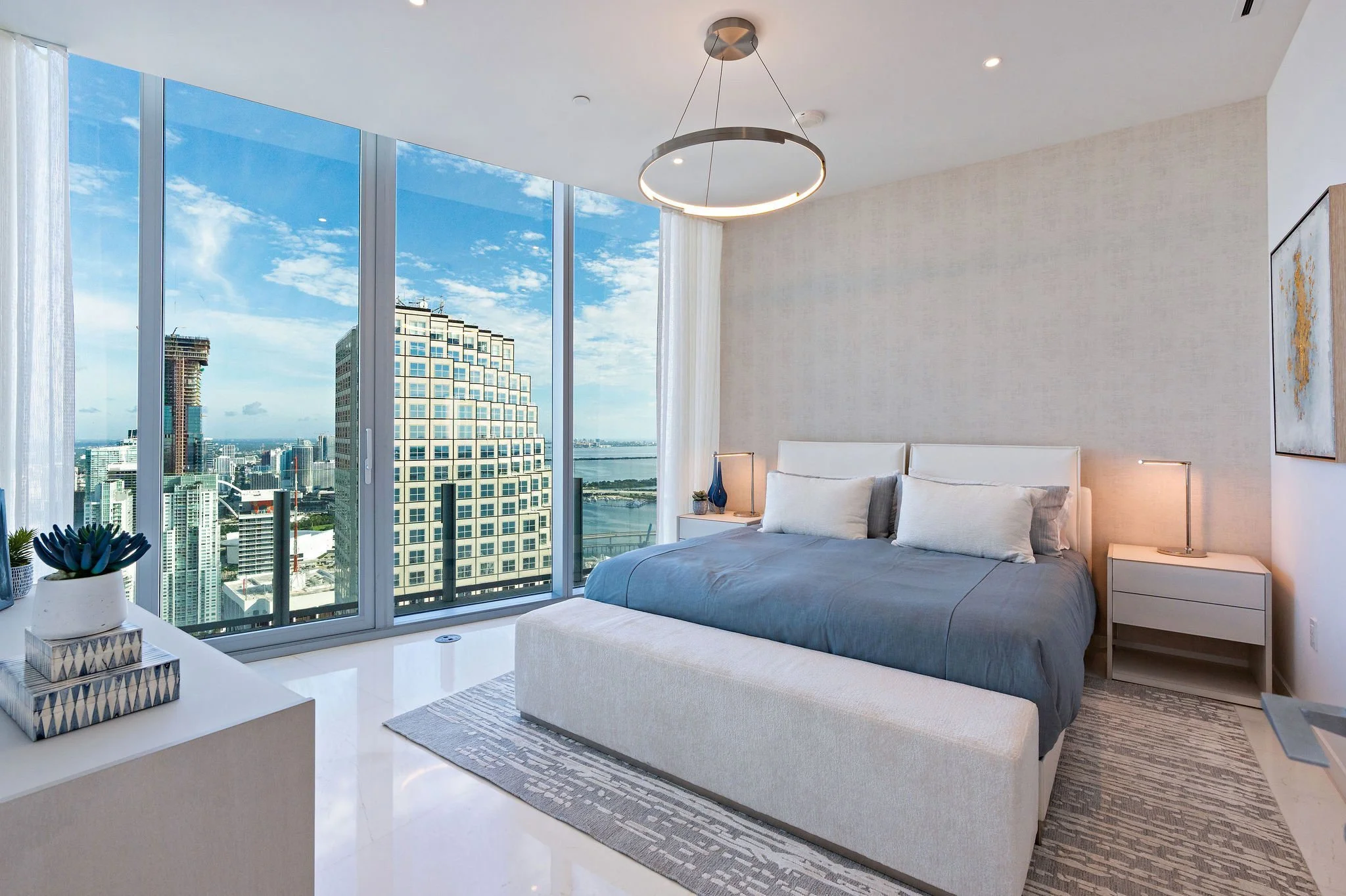 Aston Martin Residences PH6001C bedroom with muted blue bedding and city views, Miami