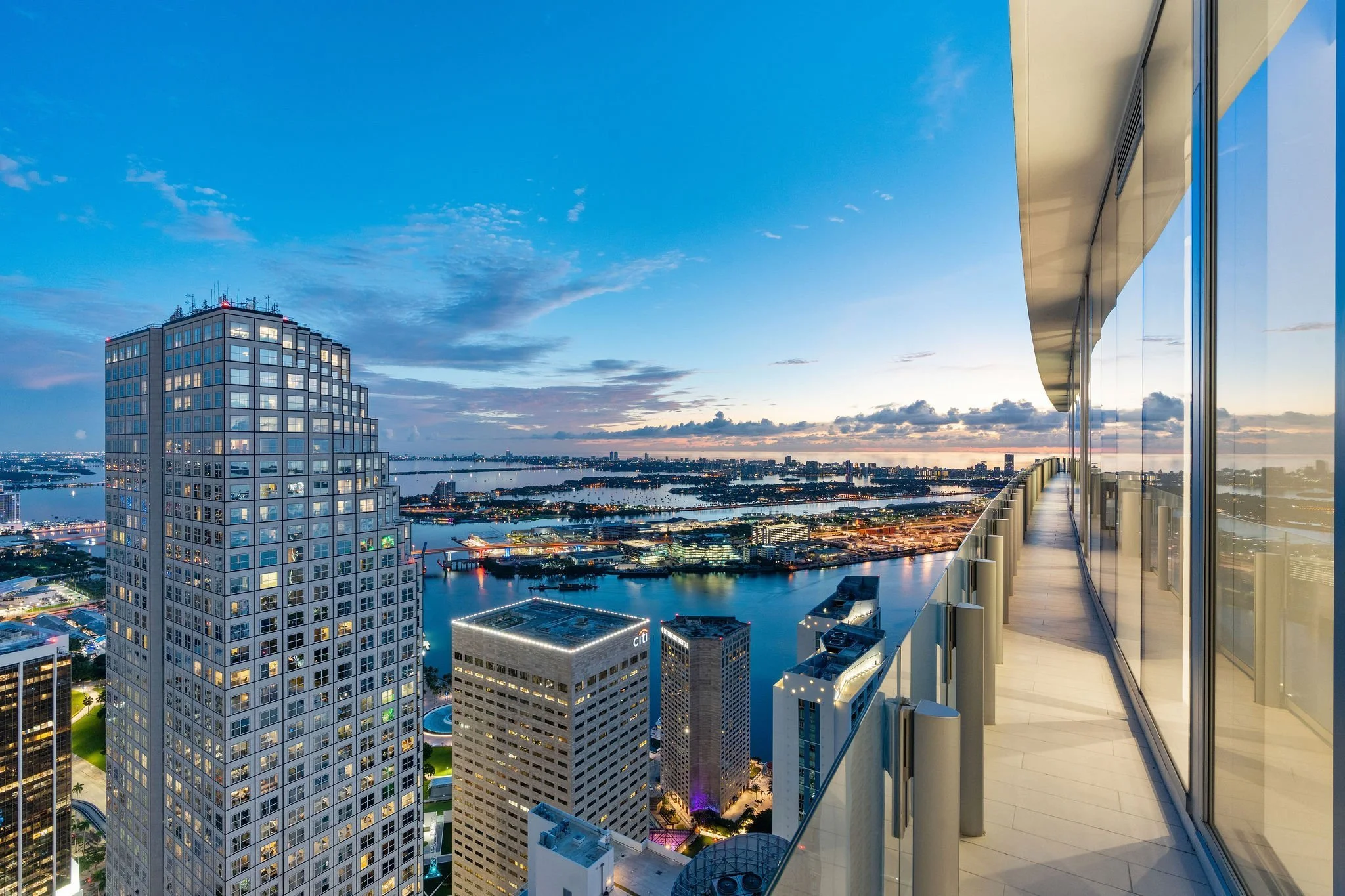 Aston Martin Residences PH6001C wraparound terrace with Miami skyline and bay at blue hour, Miami