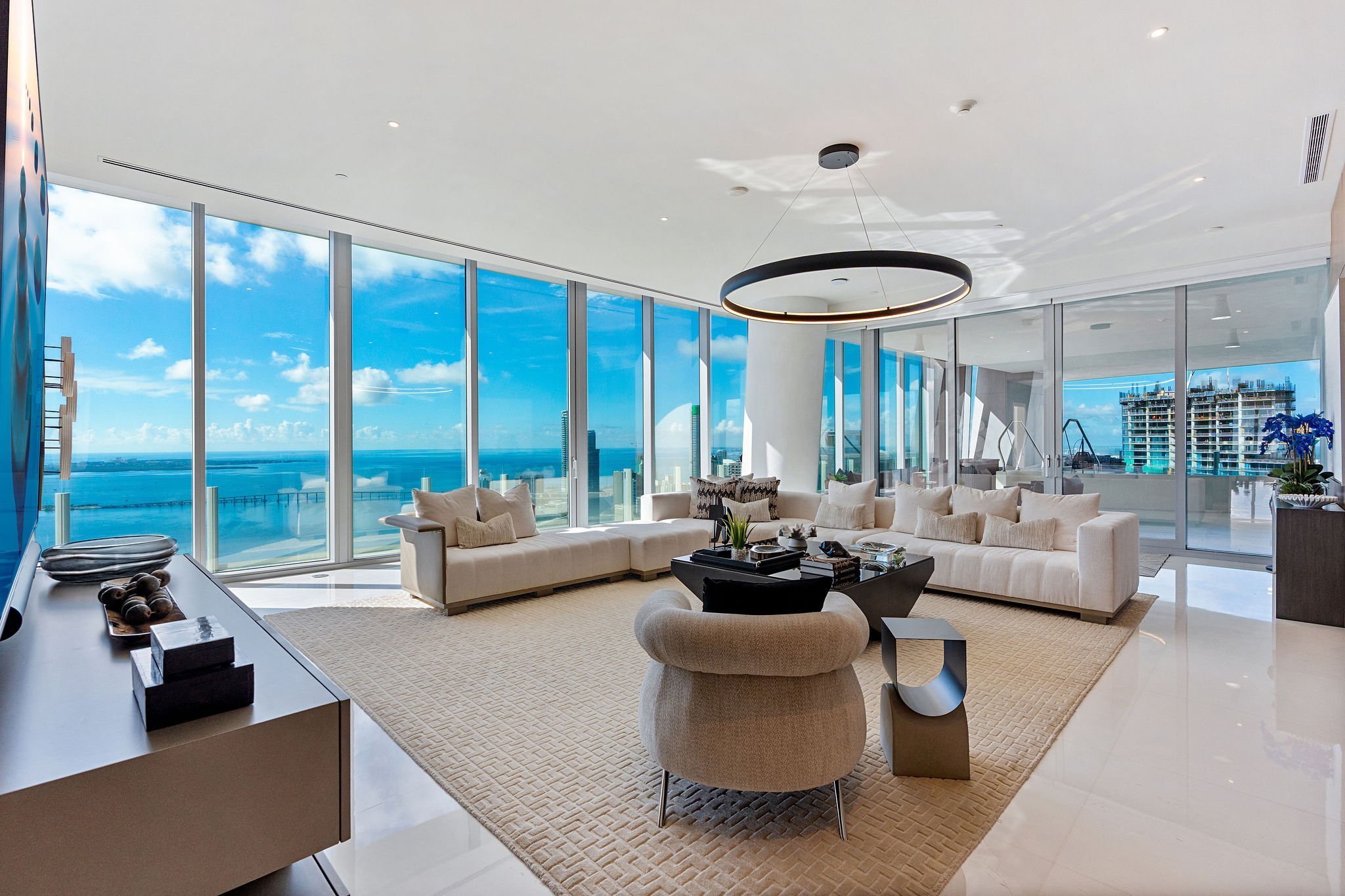 Aston Martin Residences PH6001C secondary lounge with circular pendant and bay-facing windows, Miami