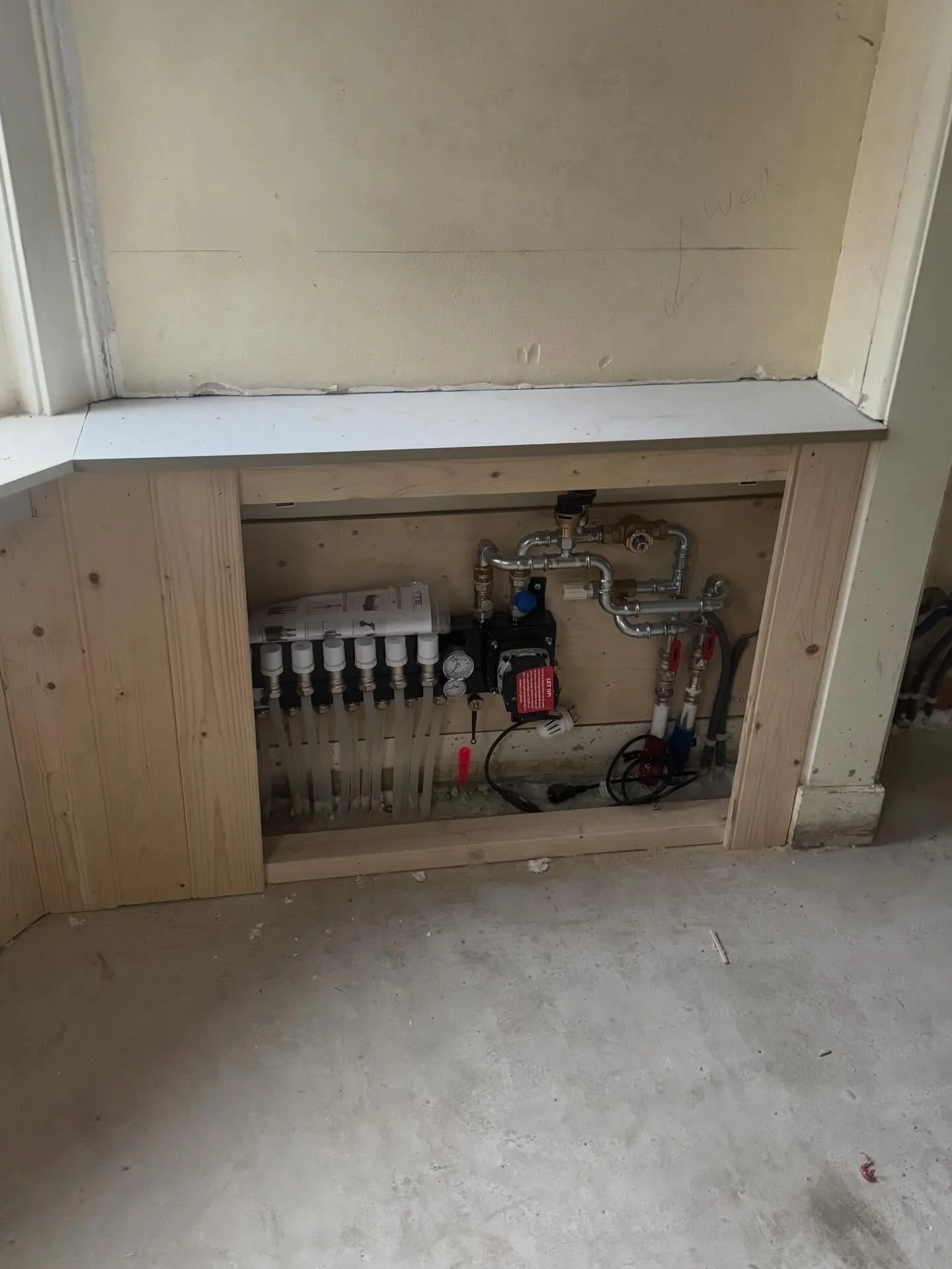 We hebben de verdeler van de vloerverwarming mooi weggewerkt achter een luik van kraaldelen passend in de stijl van het huis.