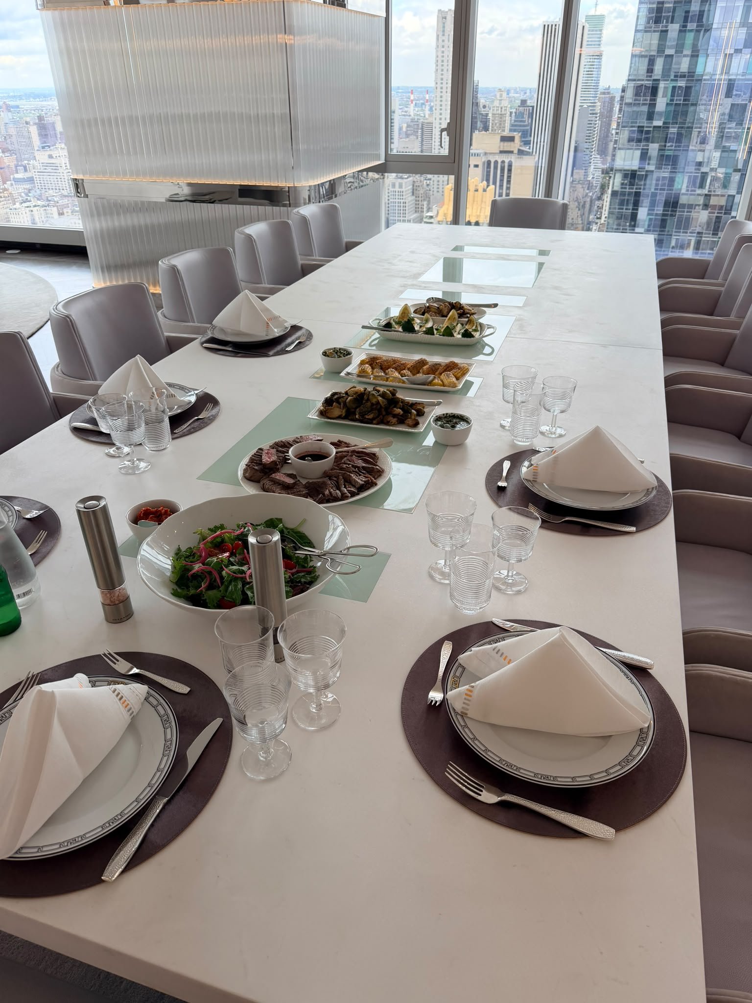 A home dining table with freshly prepared sharing dishes and New York views