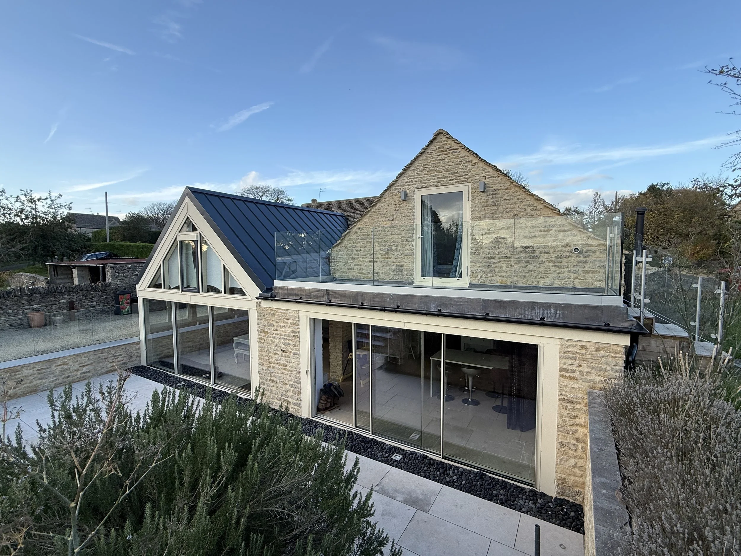Stone cottage with modern glass extensions, landscaped garden