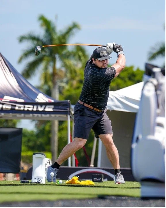 Golfer practicing a tee shot at an outdoor driving range