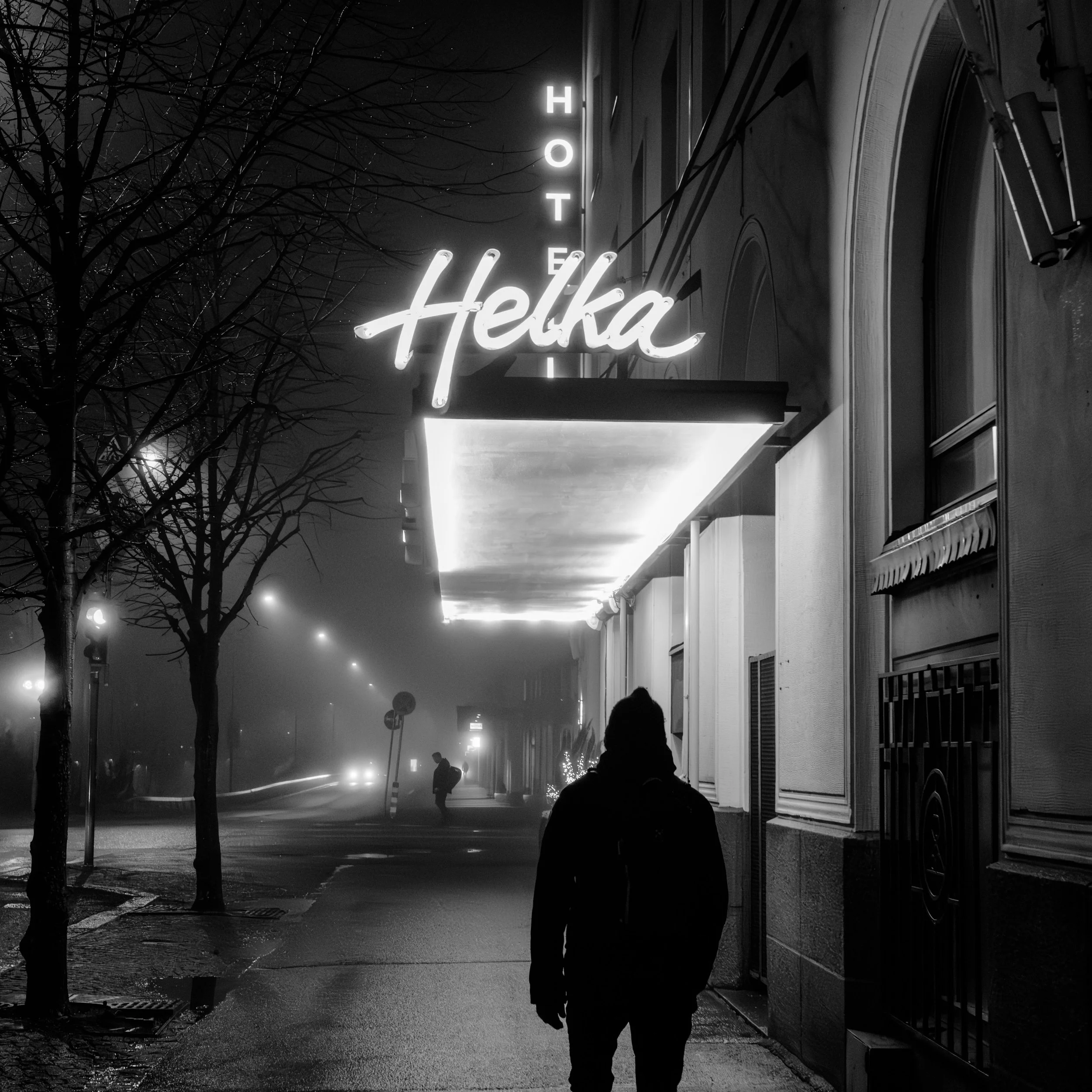Black-and-white nighttime street scene with a glowing hotel sign, fog, bare trees, and silhouetted pedestrians.