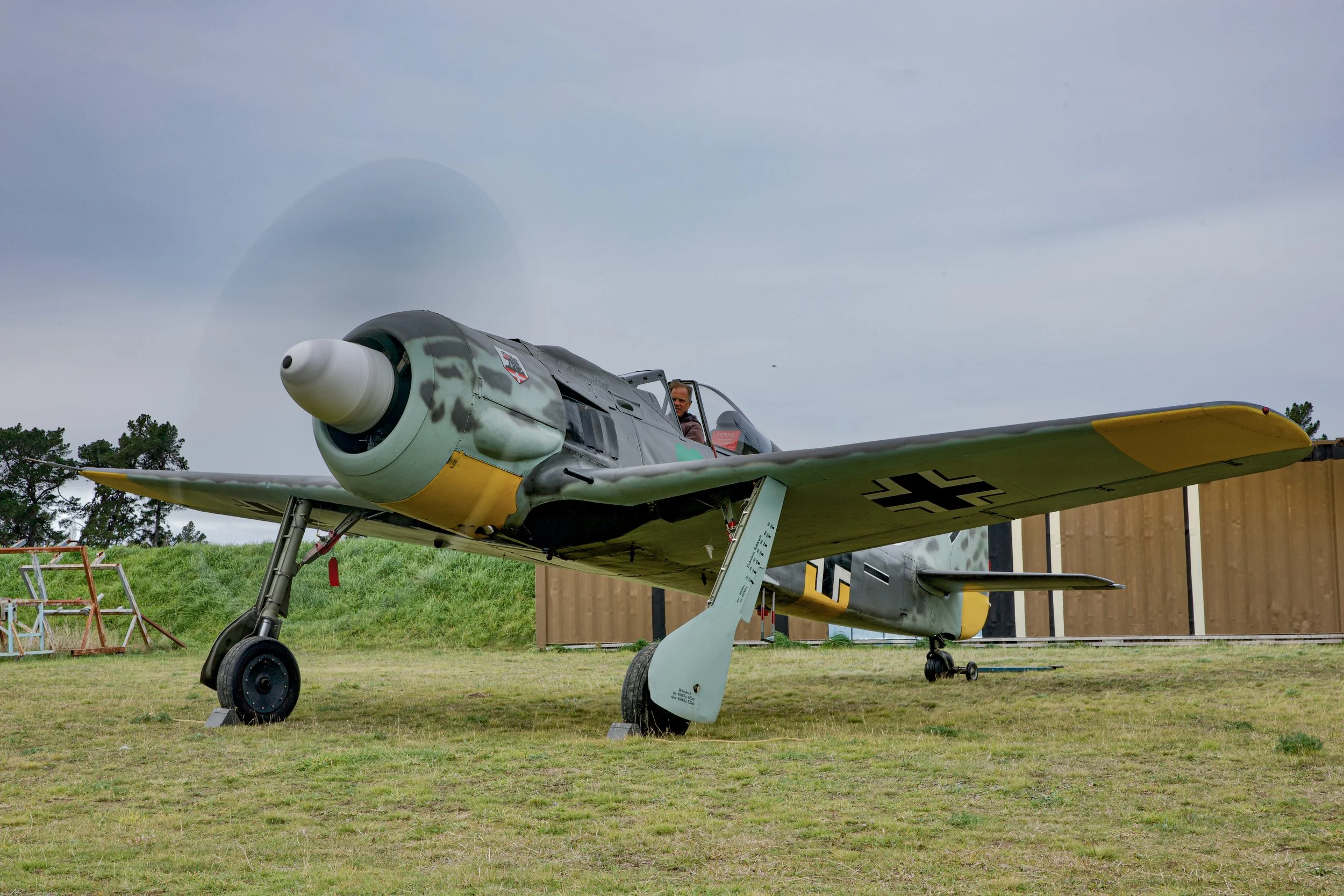 Vintage German World War II fighter aircraft displayed on grass outside a museum