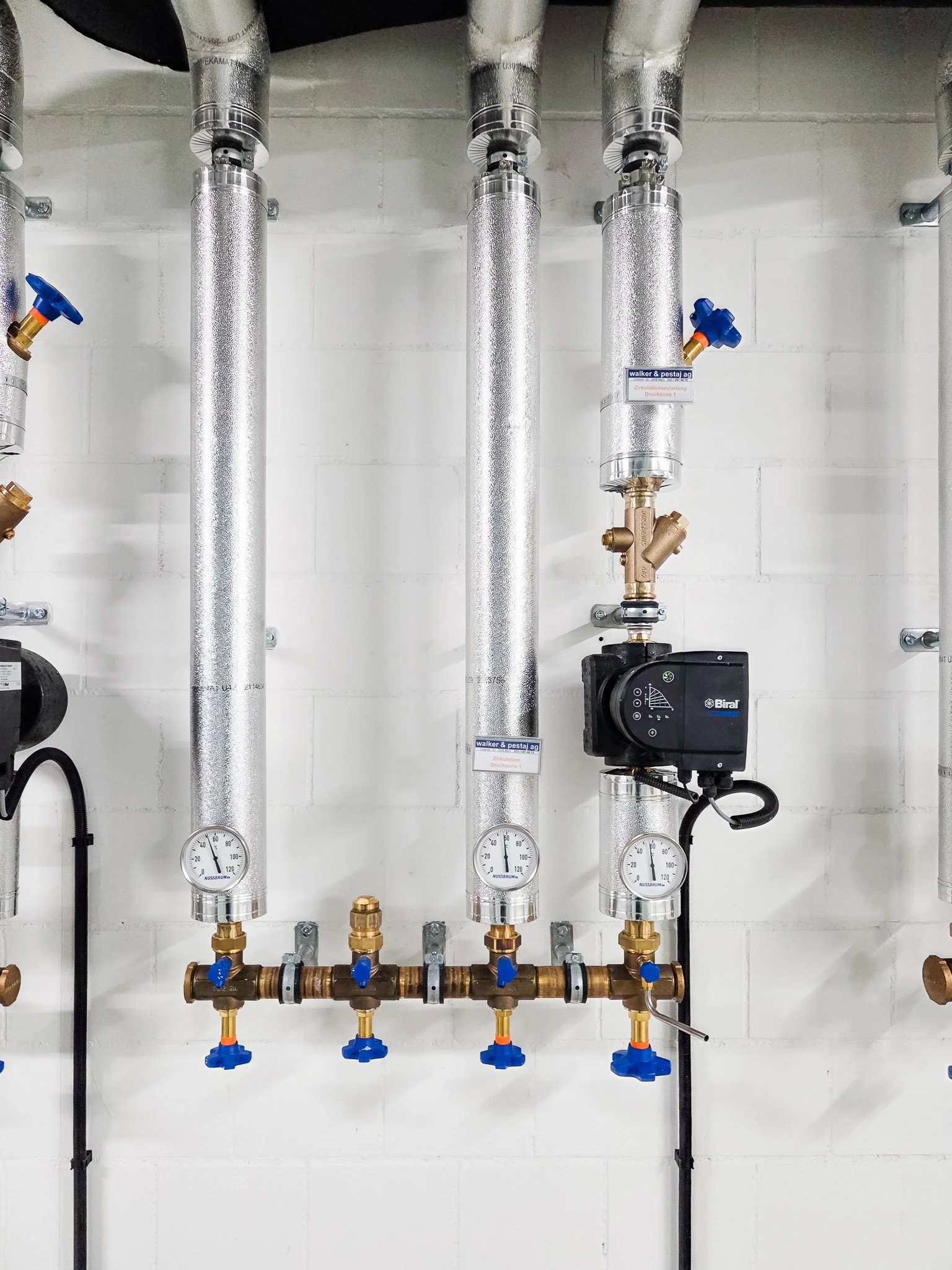Heizungsinstallation mit isolierten Rohrleitungen, Absperrventilen, Thermometern und einer Biral-Umwälzpumpe