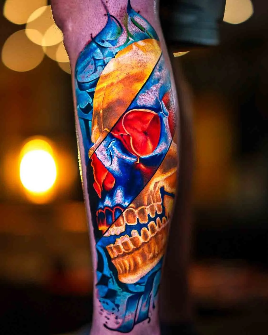 Abstract skull tattoo divided into blue, red and yellow sections.