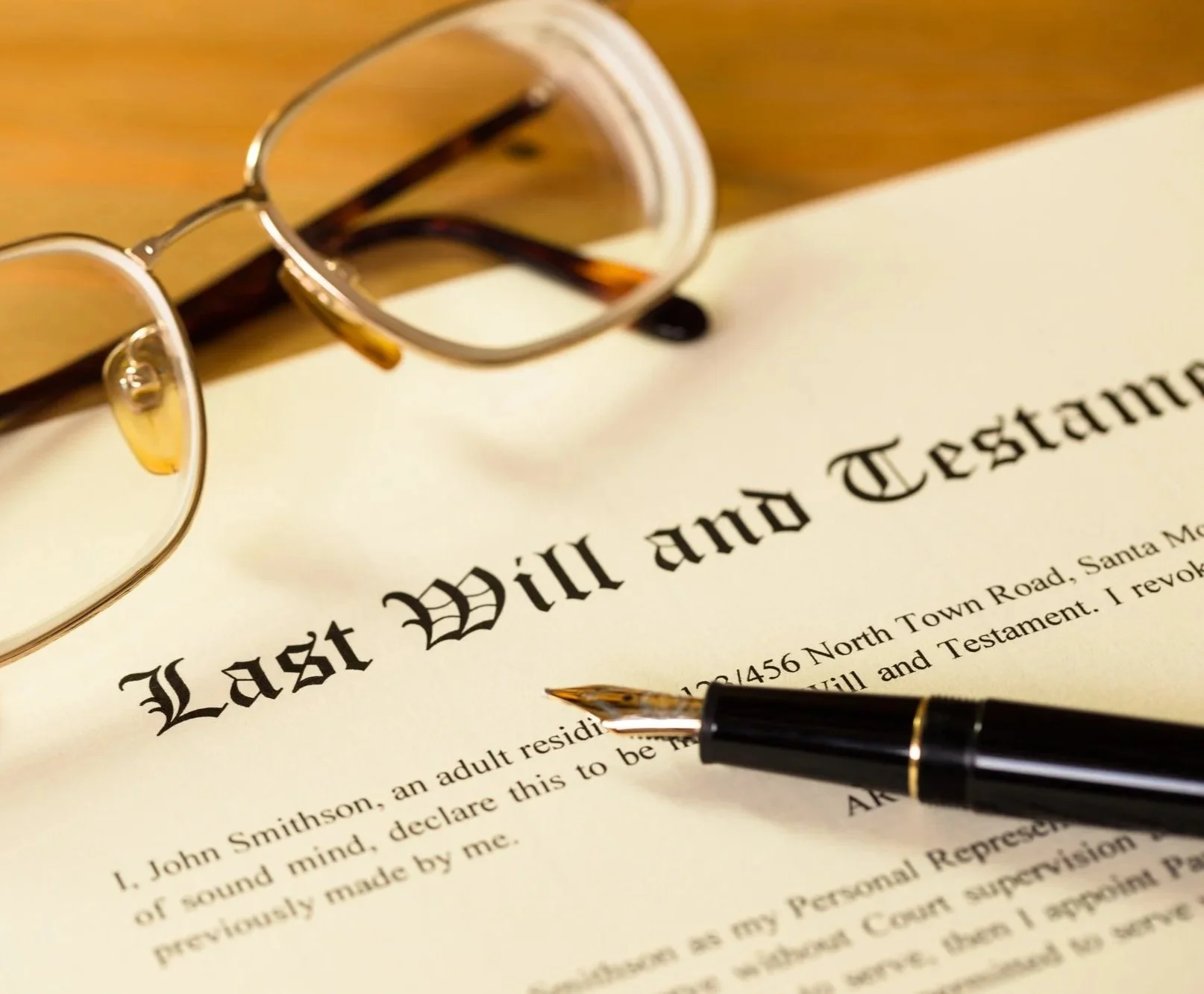 Eyeglasses and fountain pen resting on a last will and testament document
