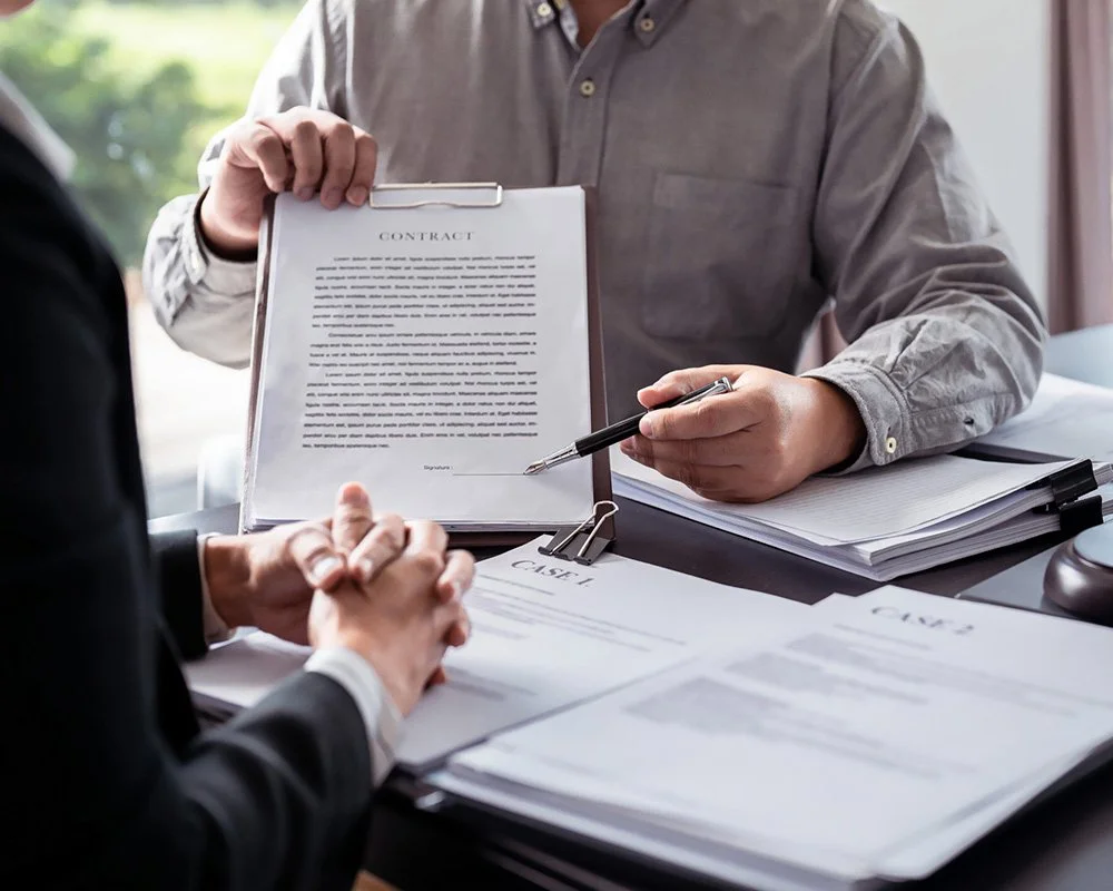 Business professionals reviewing a contract and paperwork at a desk