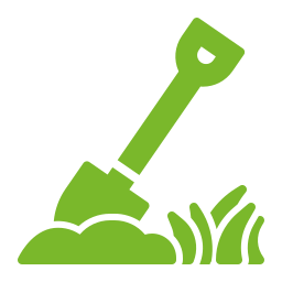 Green shovel digging into soil beside grass