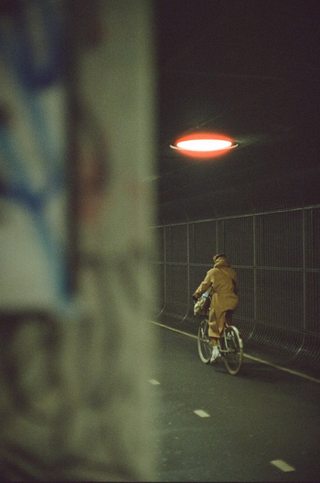 Cyclist riding through a dimly lit tunnel at night