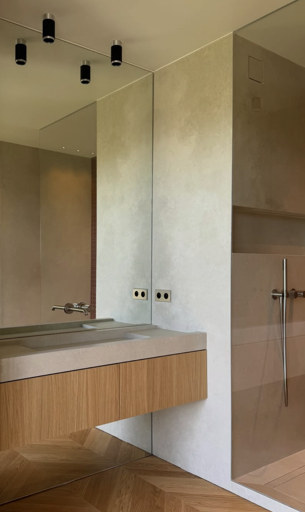 Salle de bains contemporaine avec meuble vasque en bois, grand miroir, éclairage noir et douche à l’italienne carrelée.