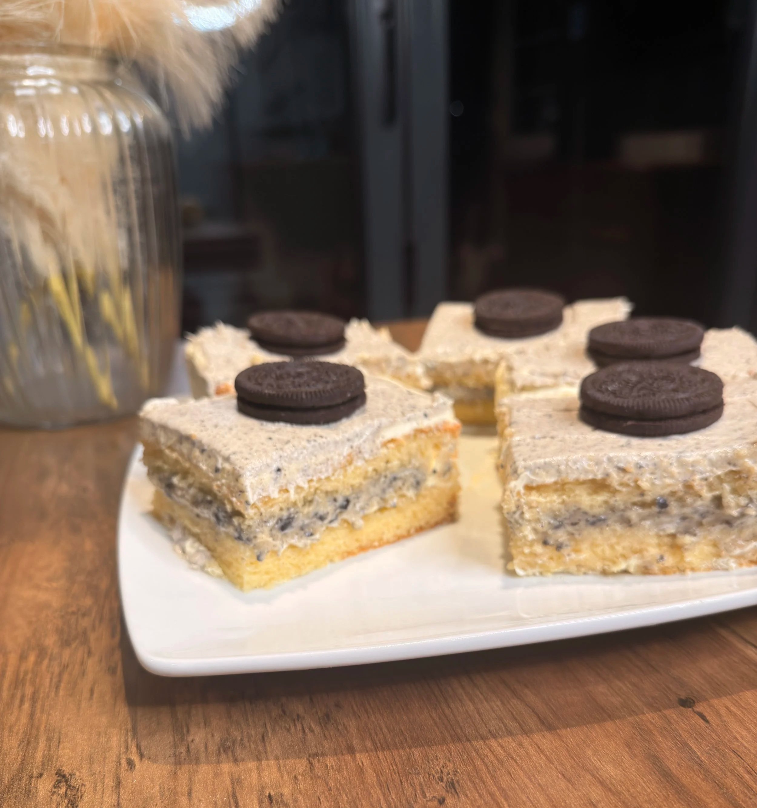 Homemade cookies-and-cream ice cream sandwiches topped with chocolate sandwich cookies on a white platter