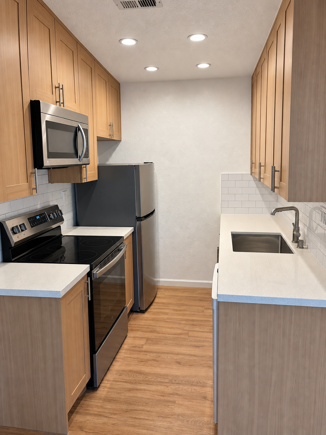 Compact kitchen with wood cabinets, white countertops and tile backsplash