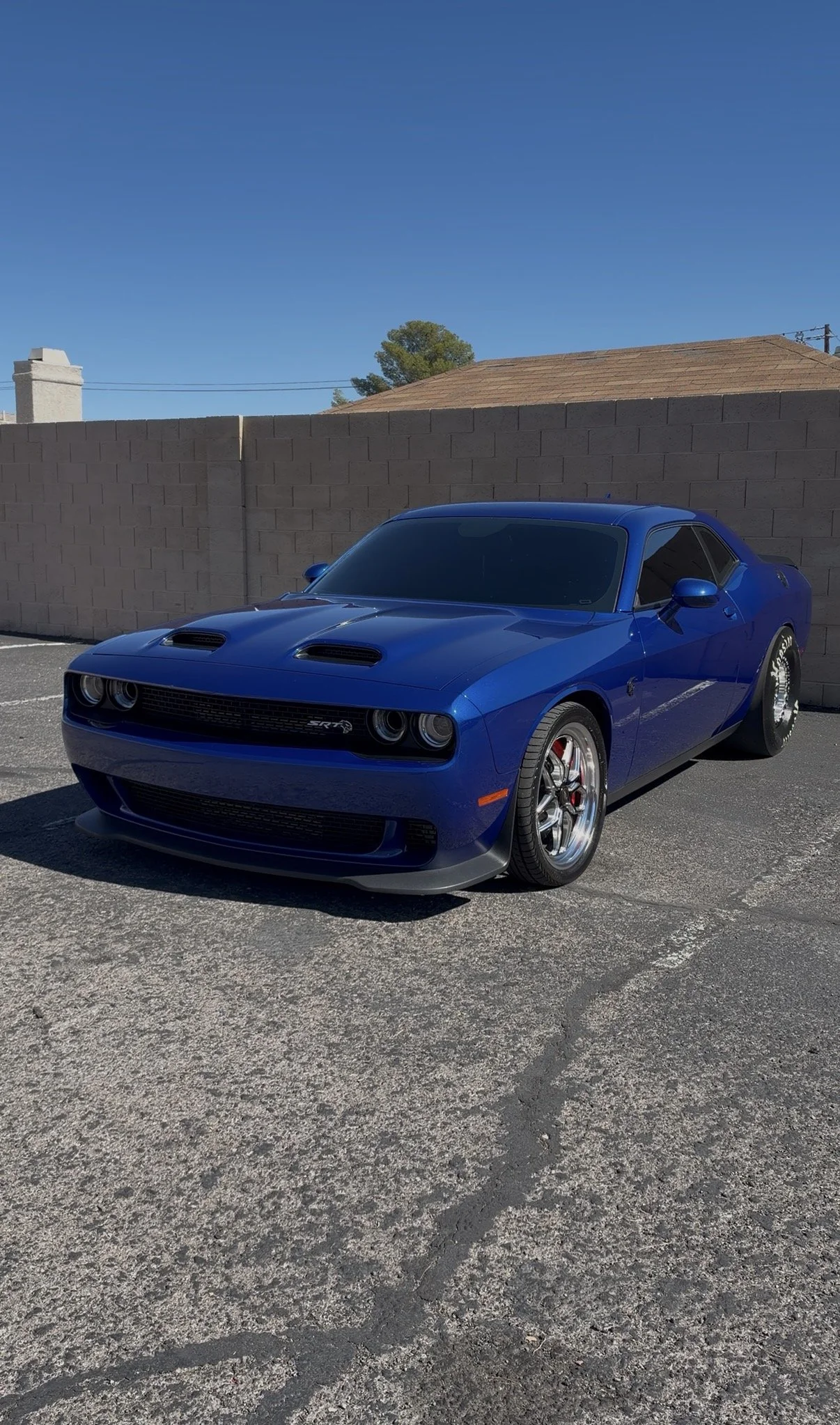 Blue Dodge Challenger SRT parked in a sunny parking lot