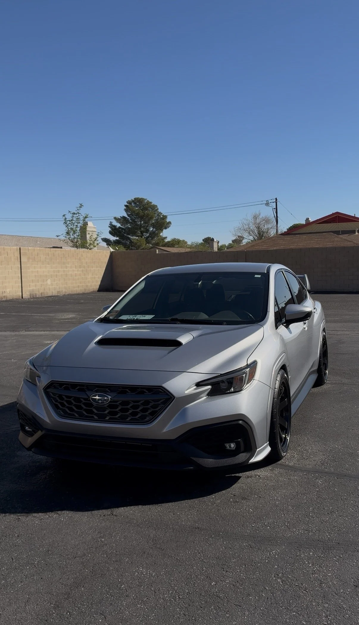 Silver Subaru WRX parked in a sunny residential driveway.