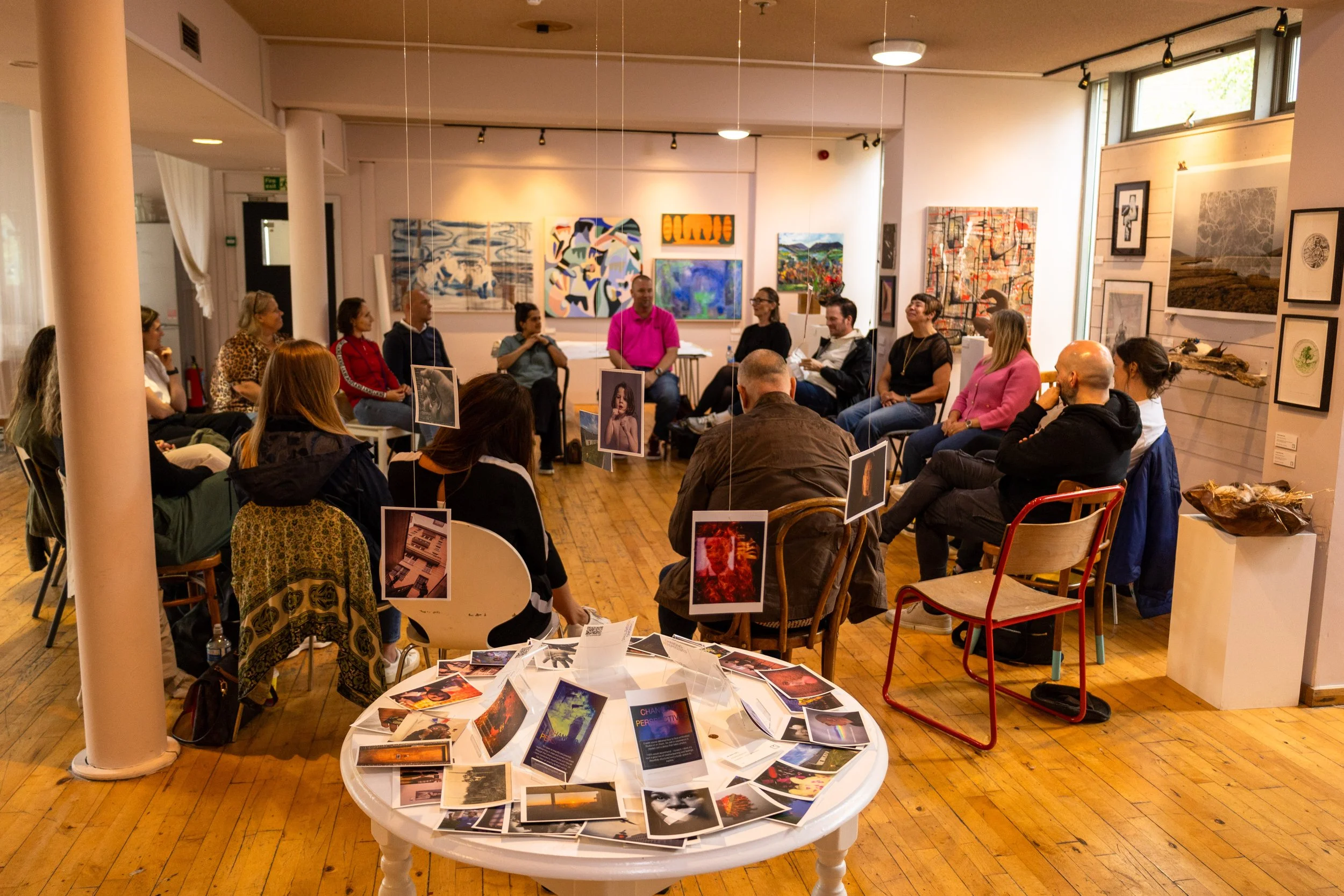 People attending Jon Rees Changing Perspectives workshop in a gallery surrounded by paintings and photographs