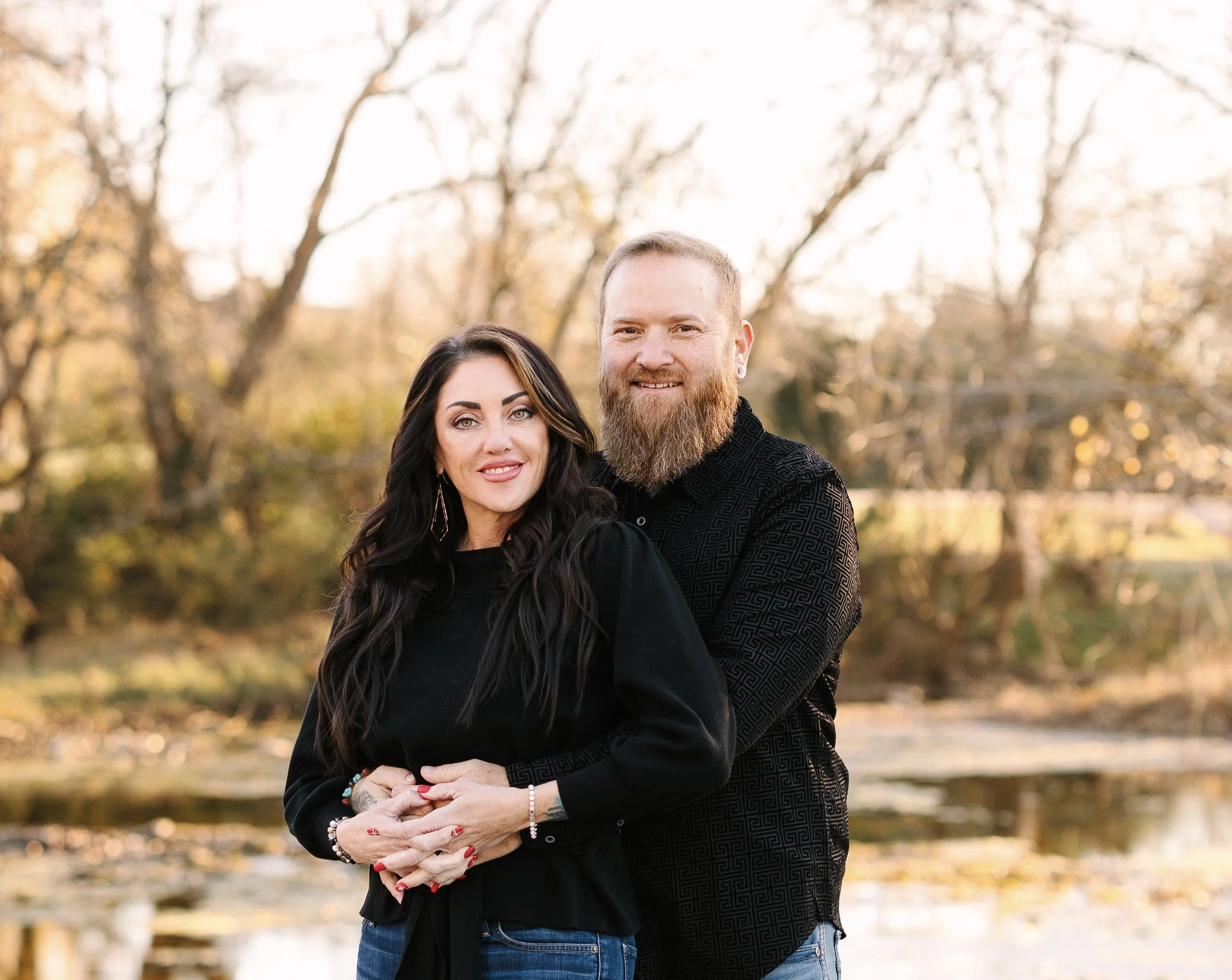 Smiling couple embracing outdoors in a sunlit autumn park