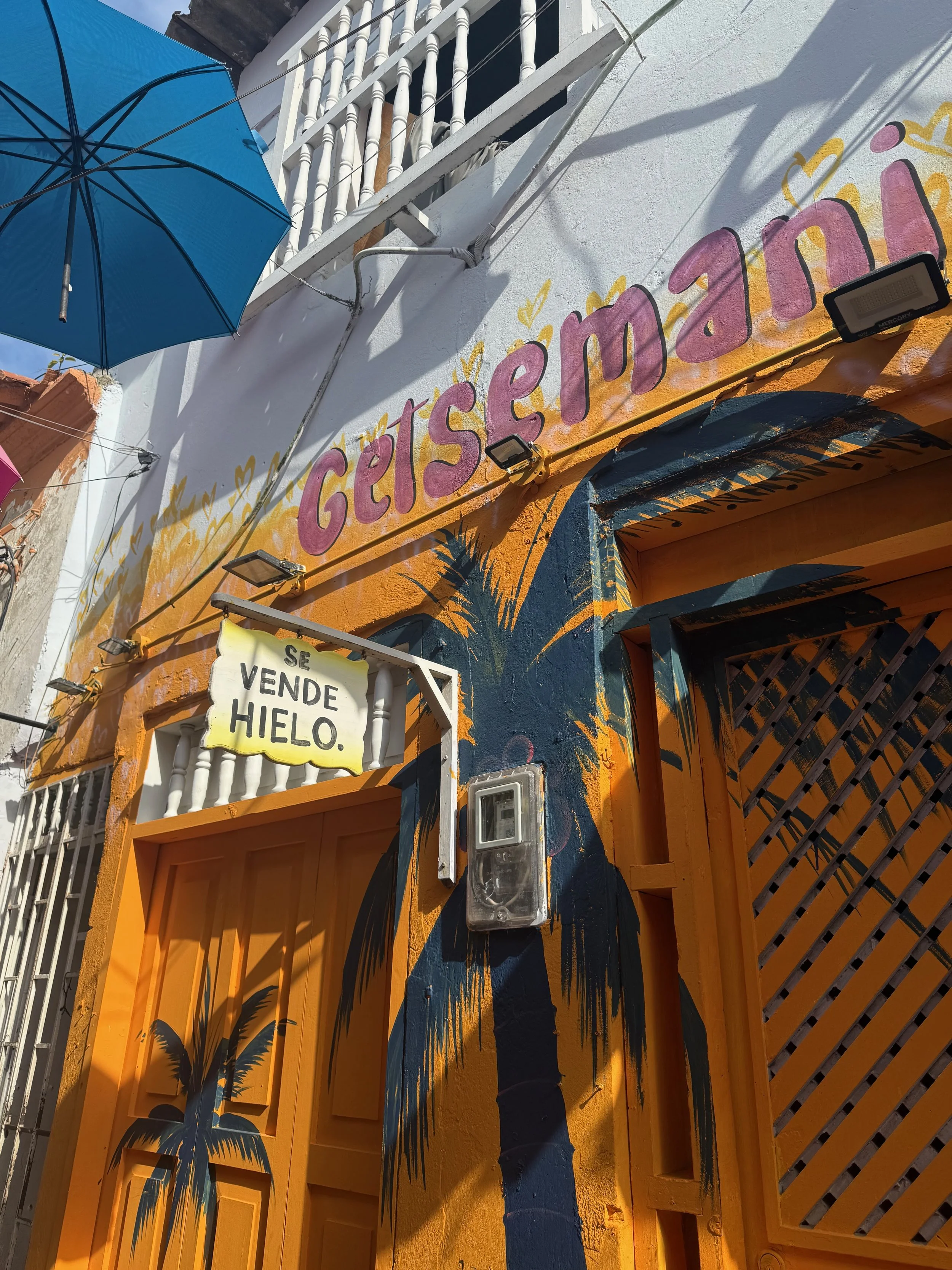 A colorful orange doorway and painted palms in Getsemaní, Cartagena, Colombia.