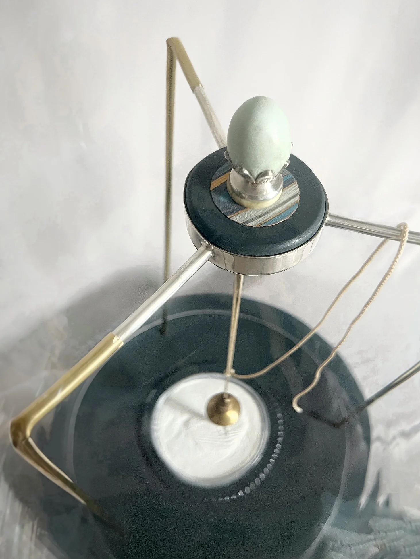 Close-up of a vintage turntable with a black platter, tonearm, cartridge, and center spindle.