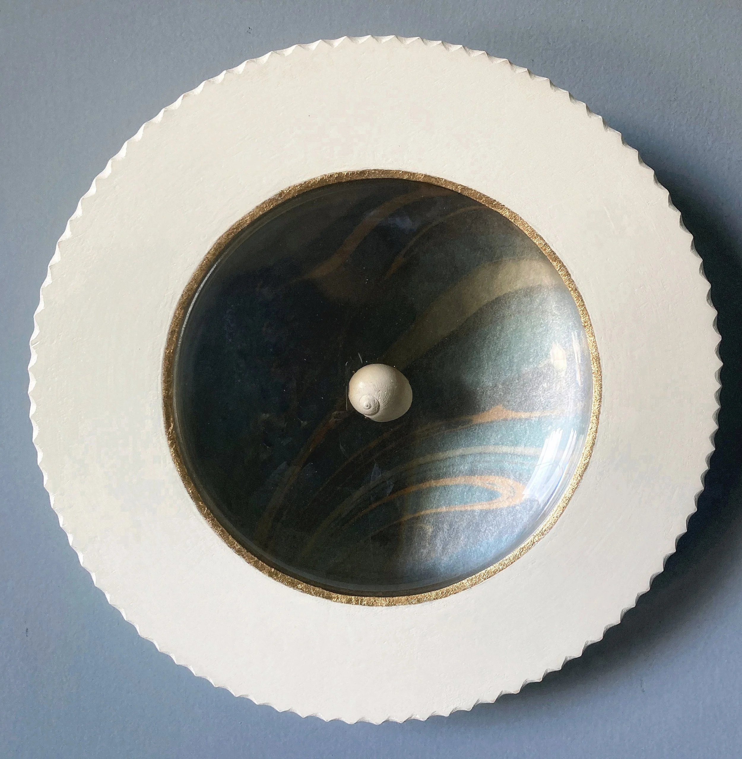 Round vintage wall clock with a dark glass face, gold trim, and scalloped white frame