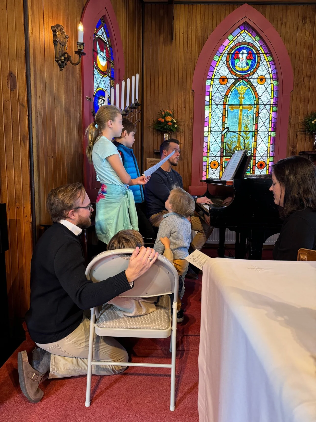 Children singing around the piano in the sanctuary