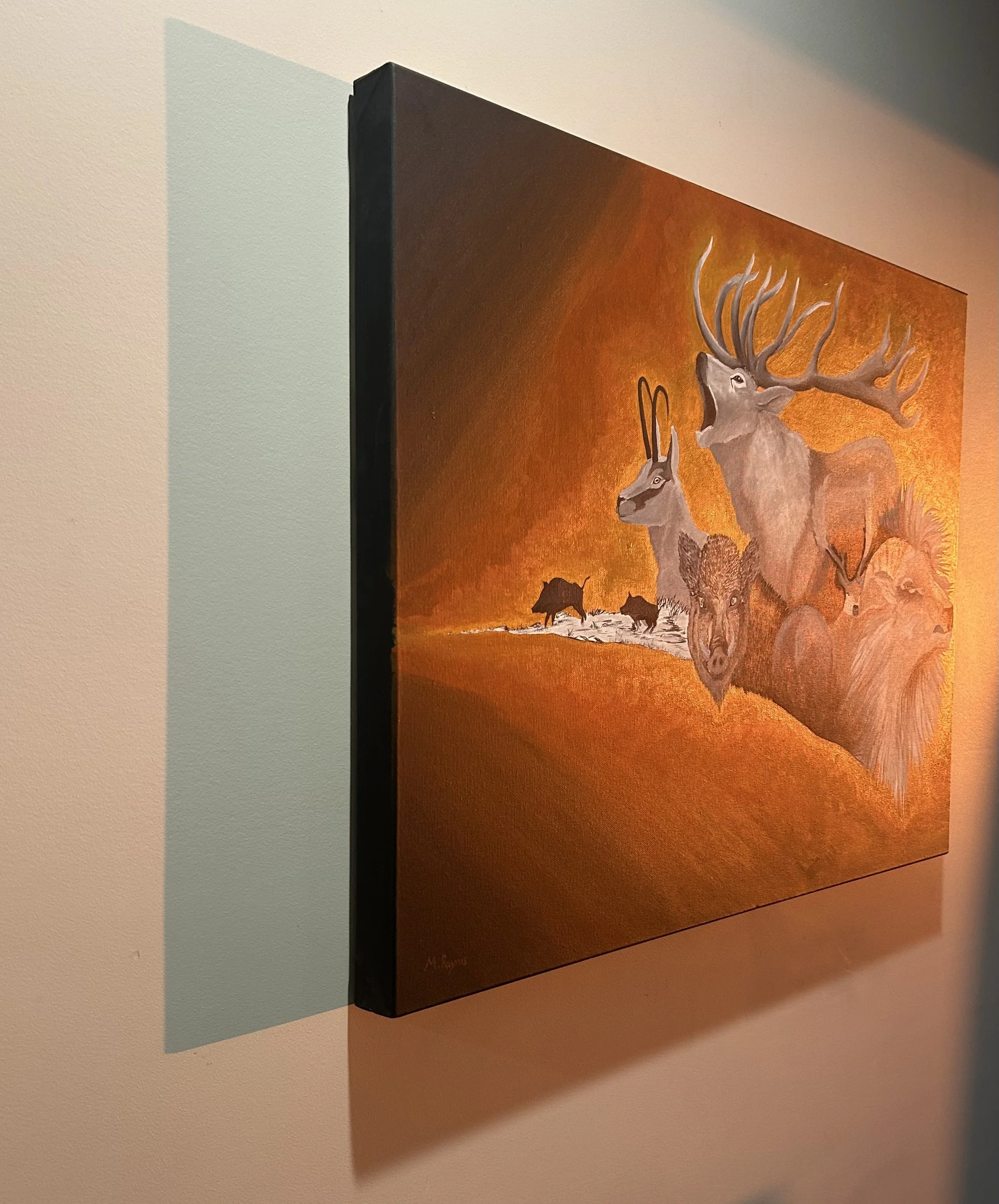 Framed wildlife painting of a large antlered elk, deer, and wolves against an orange forest landscape