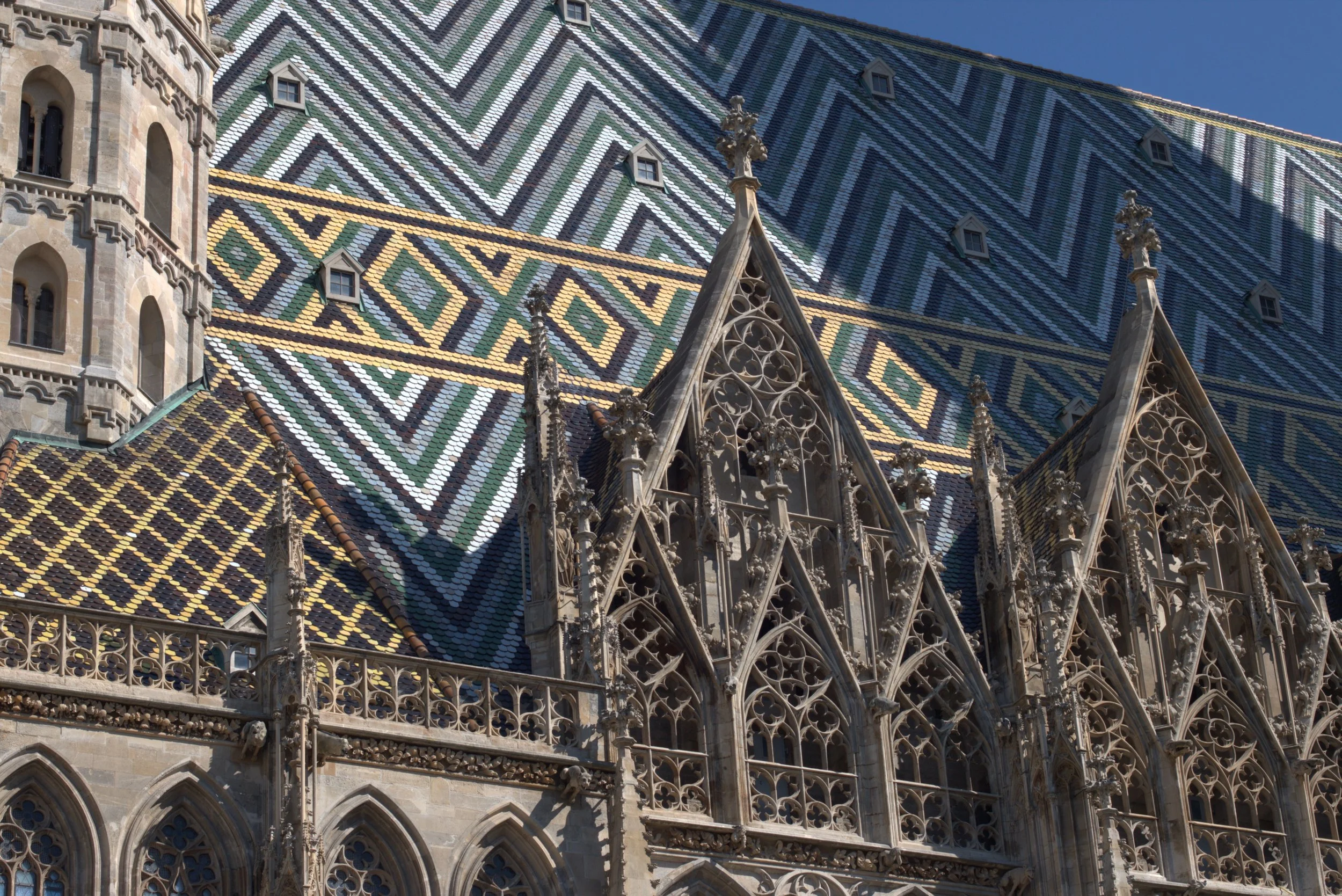 Close-up of St. Stephen's Cathedral in Vienna, featuring its colorful patterned tile roof and ornate Gothic stone façade