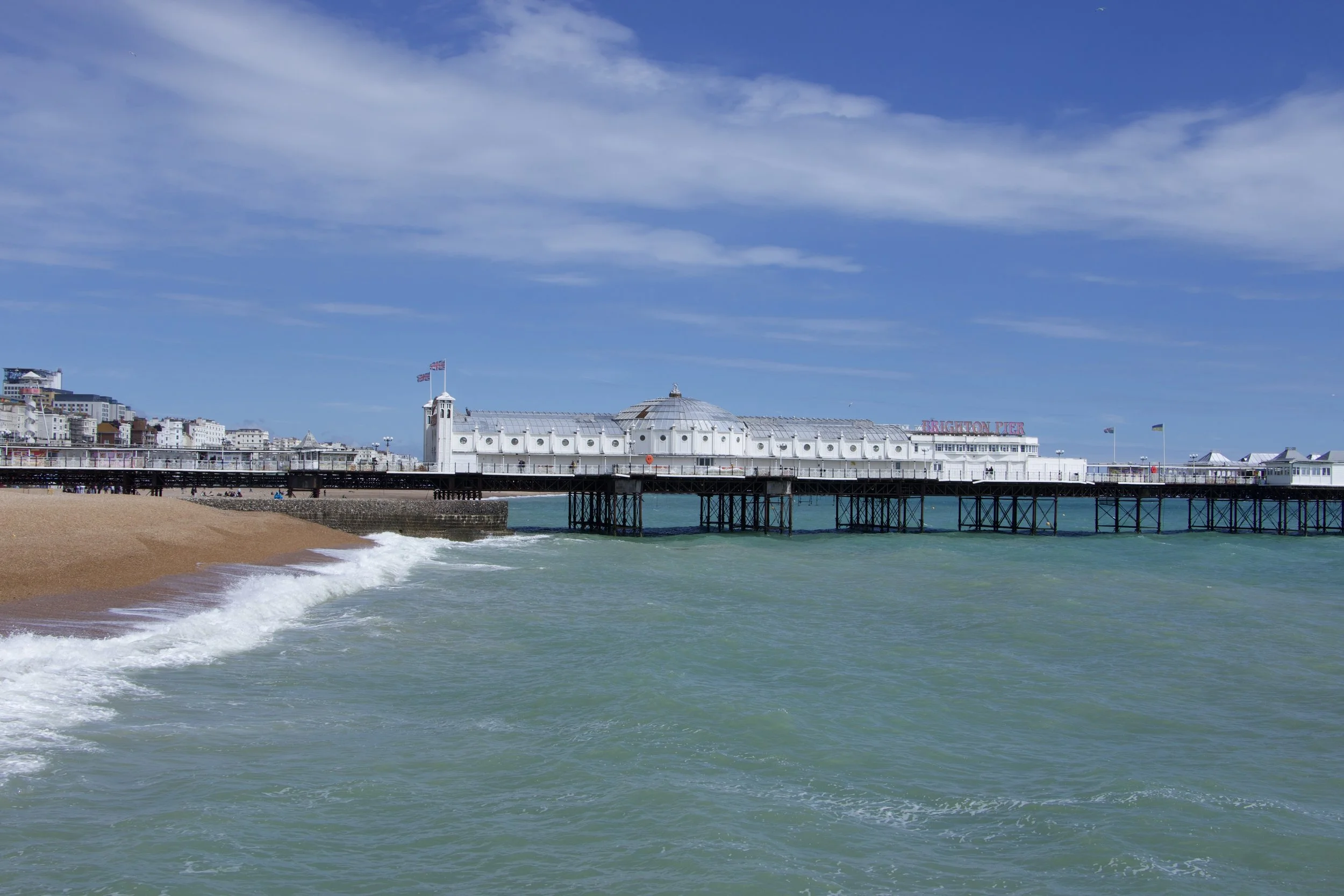 Brighton Palace Pier extending over the sea beside Brighton beach in England.