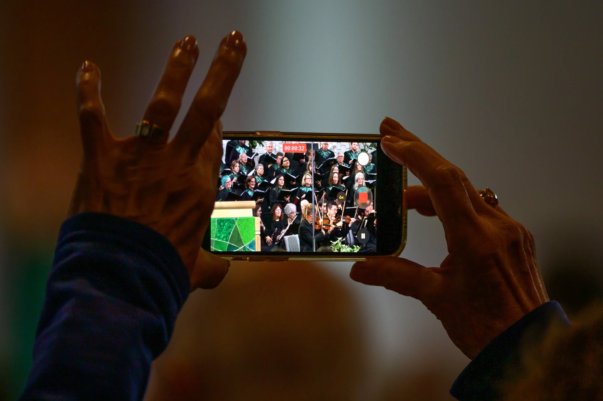 SOLI - A parishioner records the combined choirs on her phone.