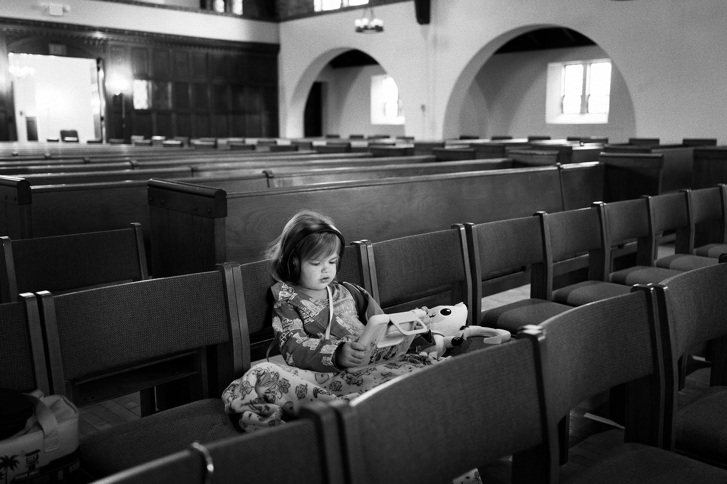100 YEARS - A child plays on her electronic device in the First Community South Campus Sanctuary while waiting for the first of two services to begin. The church chose Sunday, September 27, 2026 to celebrate the 100th anniversary of the completion of