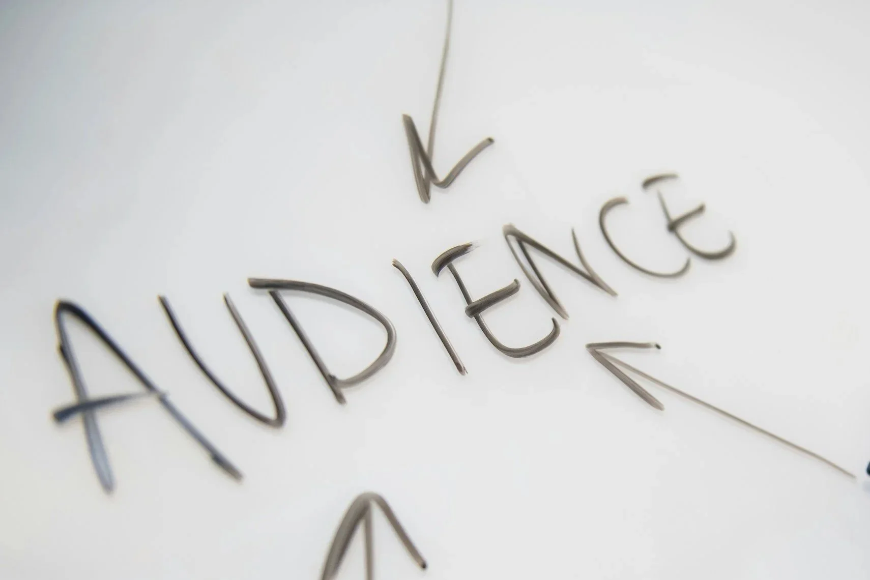 Close-up of the word 'AUDIENCE' spelled out with metallic letter keys on a white surface.