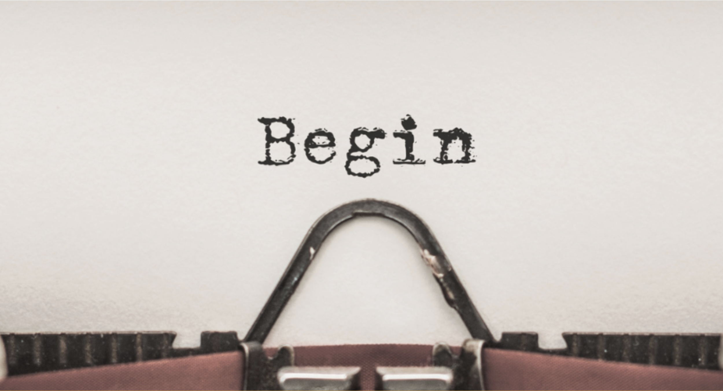 Close-up of a typewriter printing the word 'Begins' on paper.