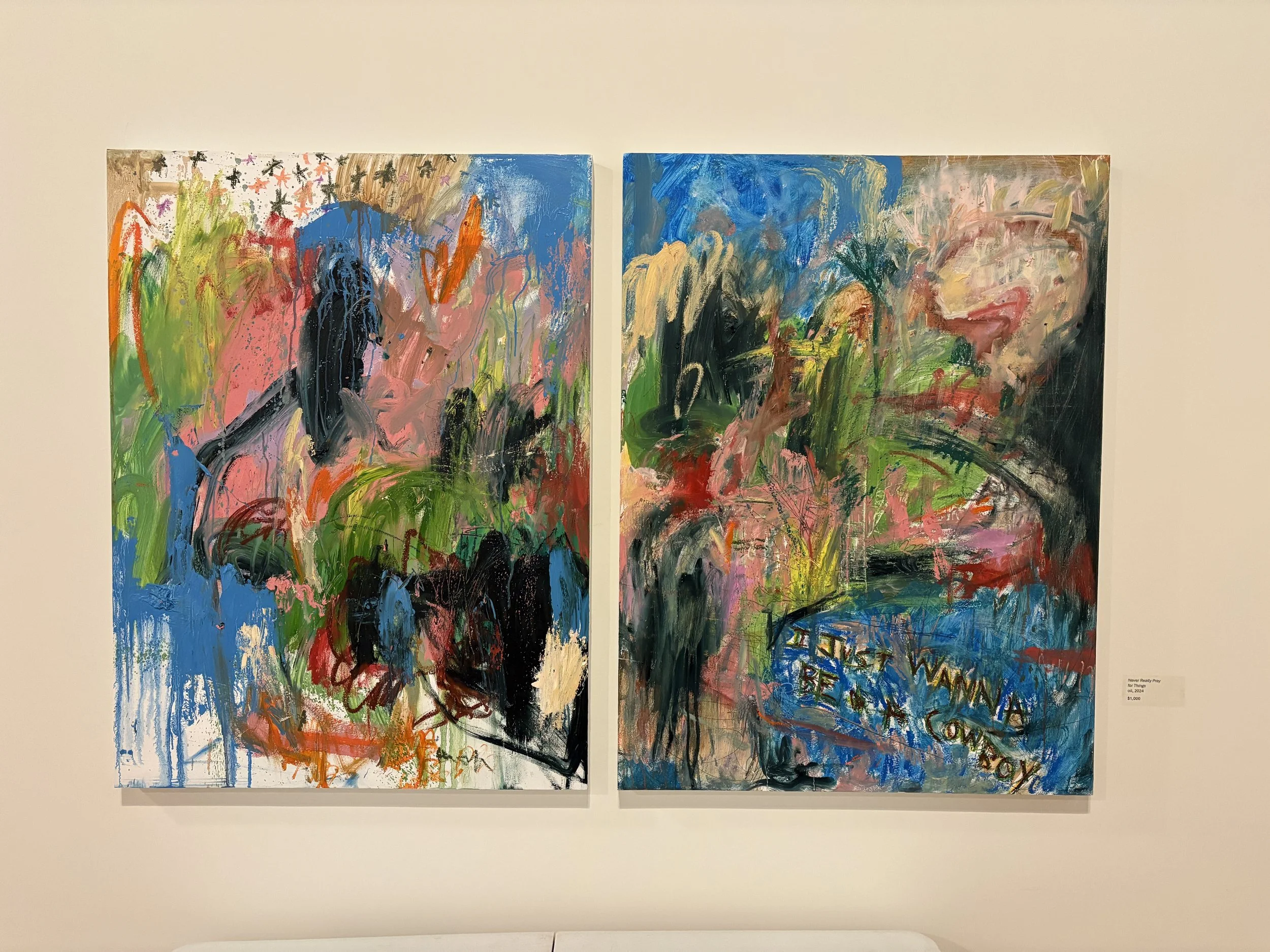 Two colorful abstract paintings displayed side by side in a gallery, featuring expressive brushstrokes and layered blue, pink, green, orange, and black forms.