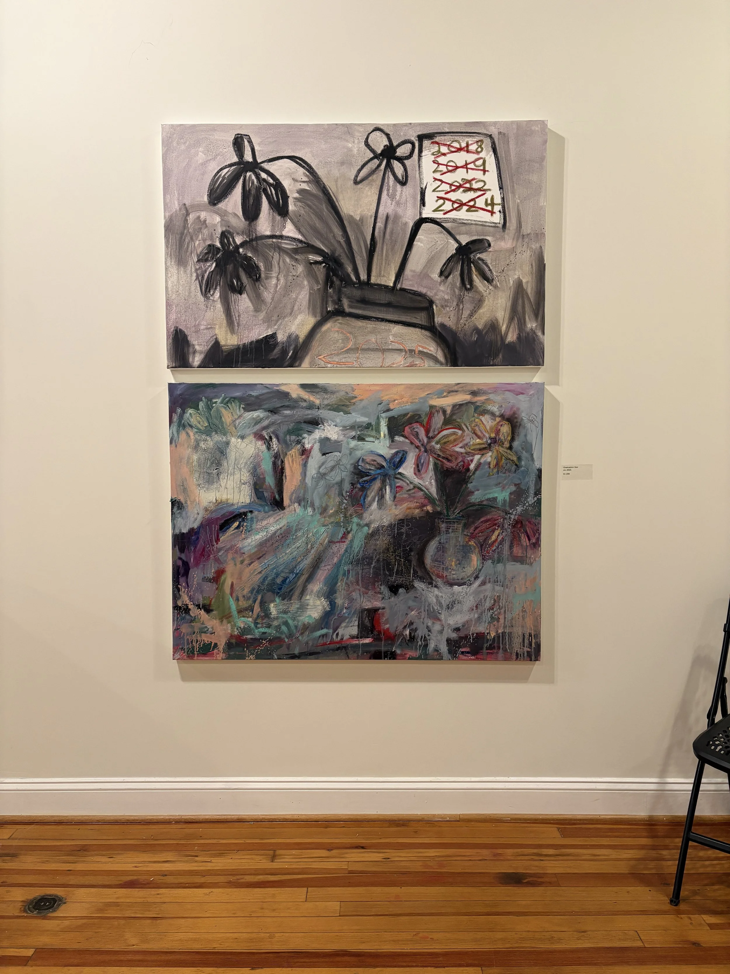 Two colorful floral abstract paintings displayed on a gallery wall, with a small artwork label beside them.