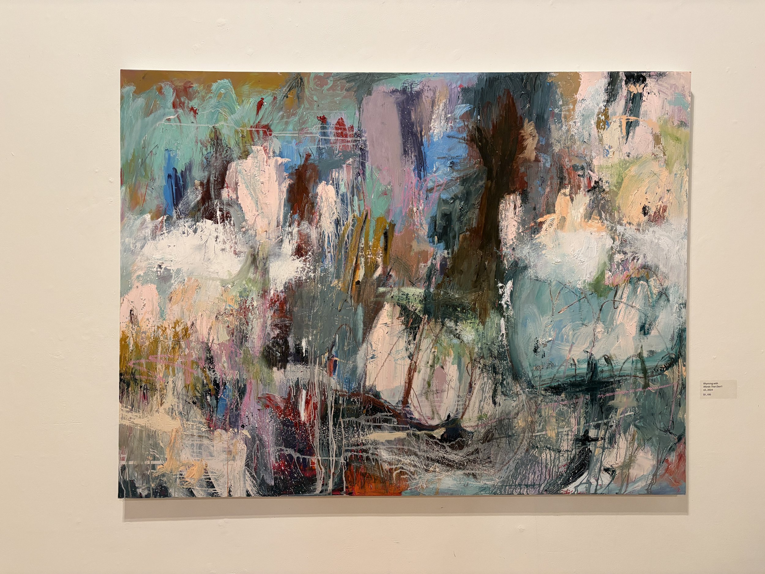 Large colorful abstract painting displayed in a gallery, featuring layered brushstrokes in teal, pink, white, brown, and black.