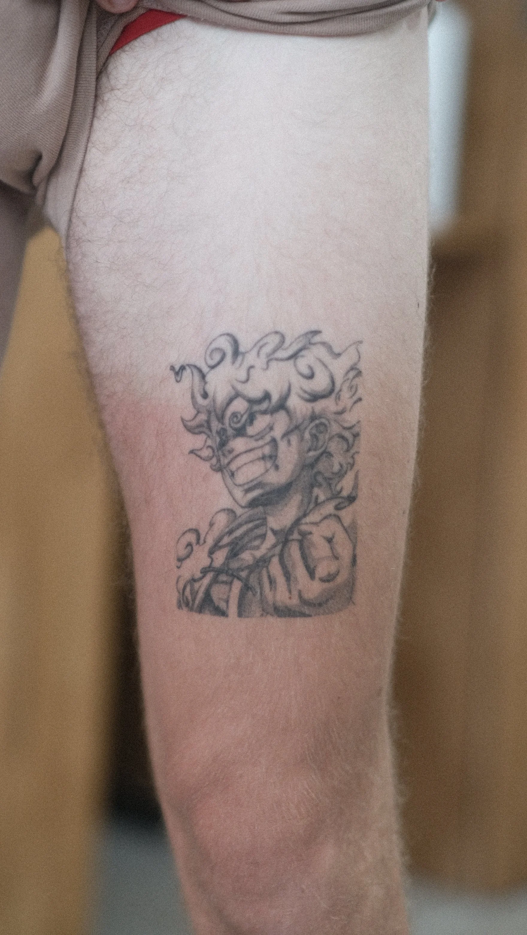 Gros plan sur un tatouage détaillé représentant un lion orné de motifs floraux sur le bras.