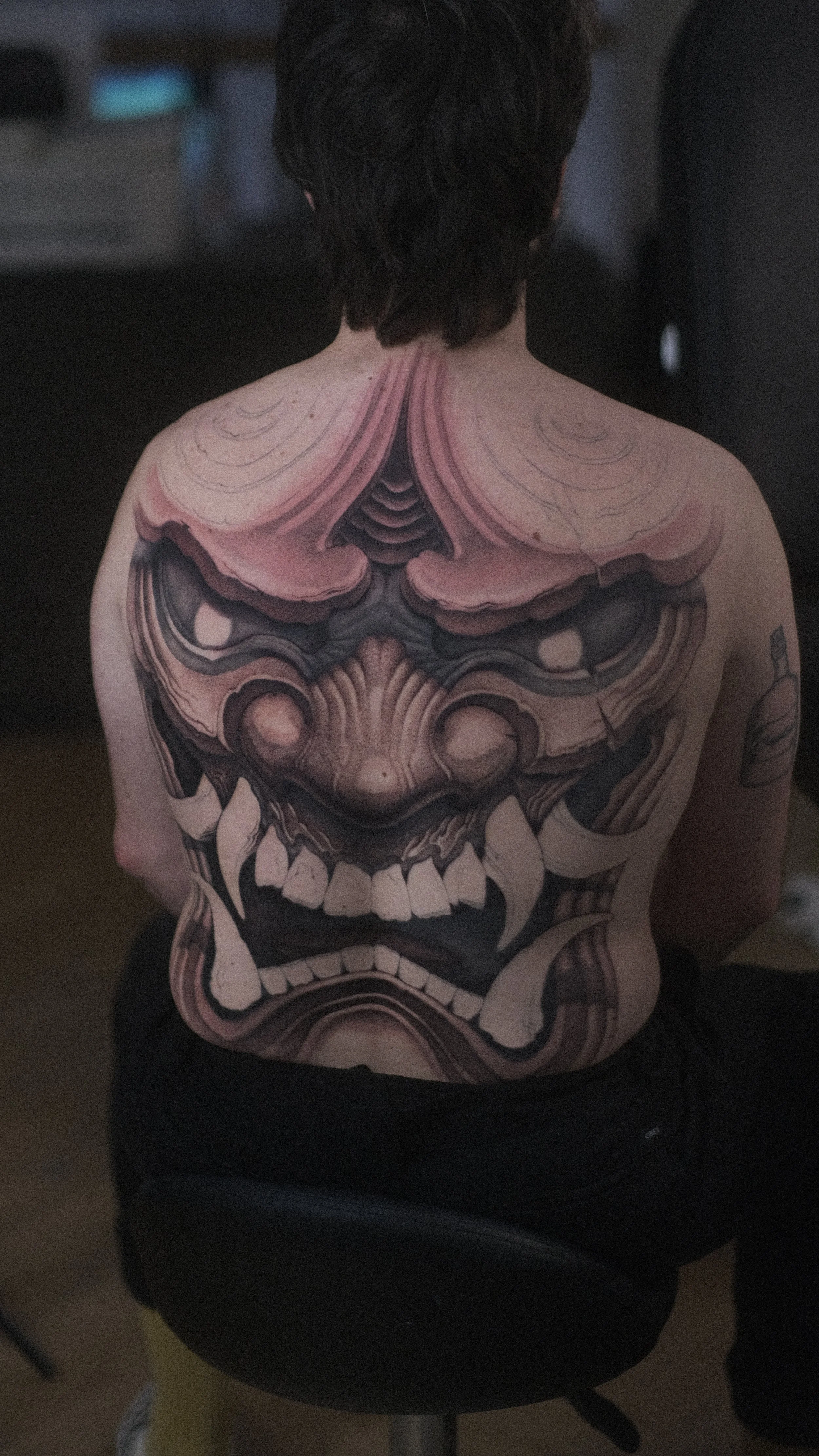 Gros plan d’un tatouage réaliste représentant un crâne humain sur le dos d’une personne.