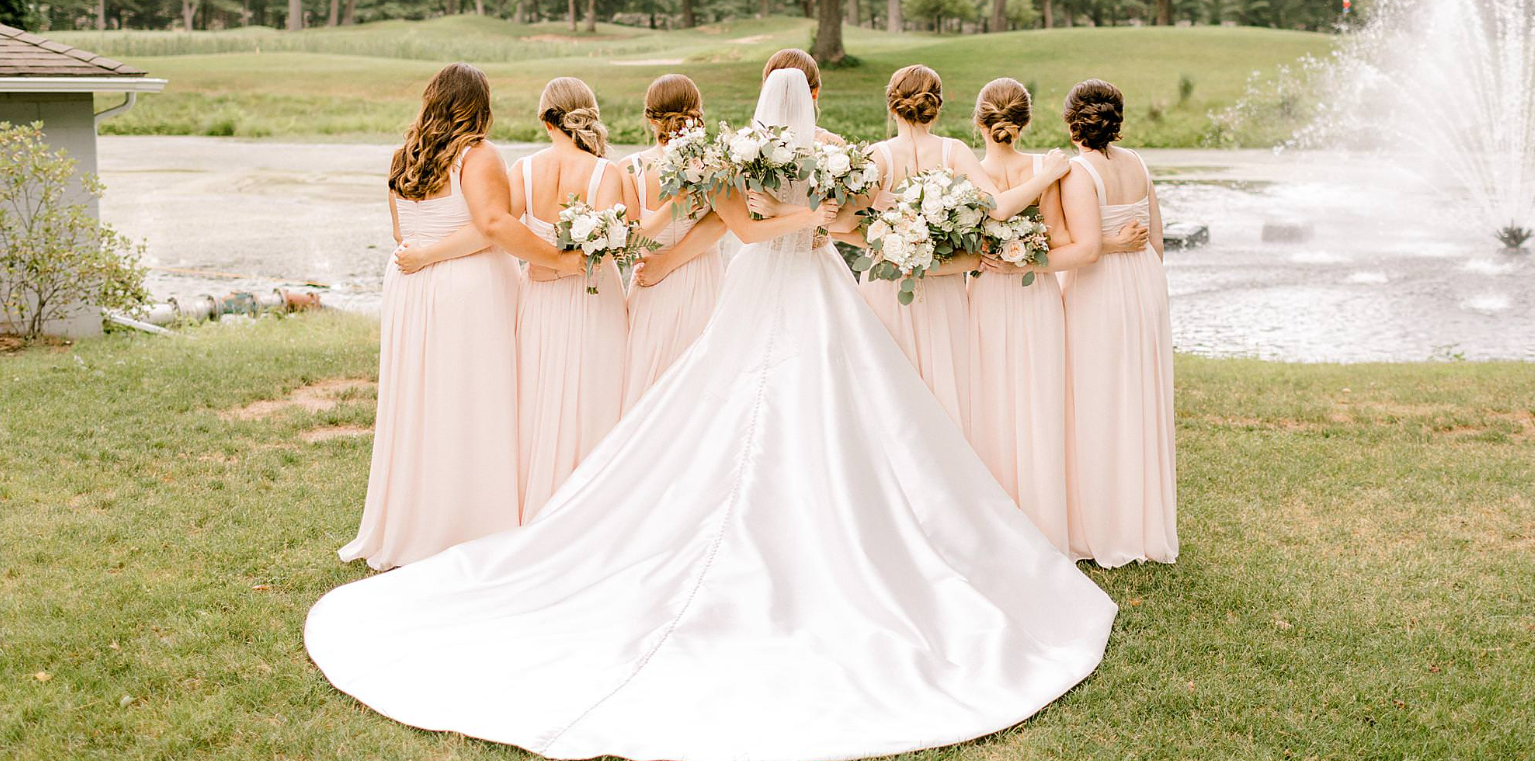 Bride and bridesmaids beside the pond