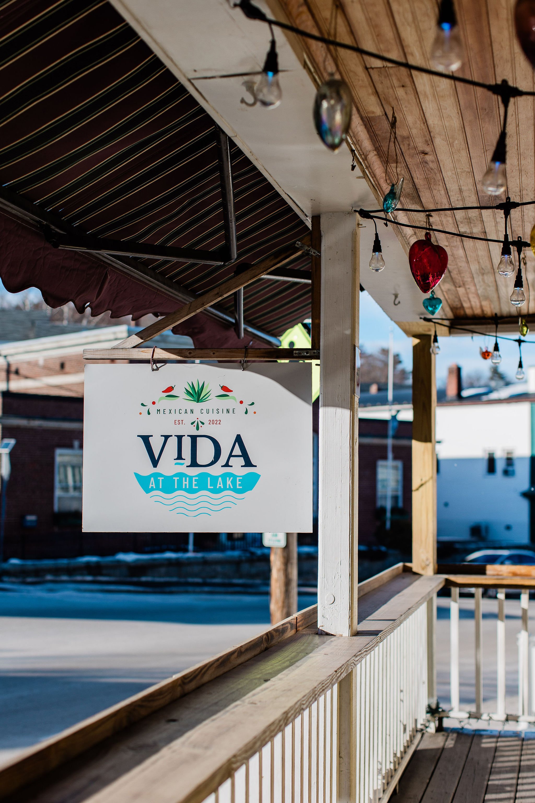 Vida at the Lake Mexican cuisine sign on a lakeside deck decorated with colorful hanging lights