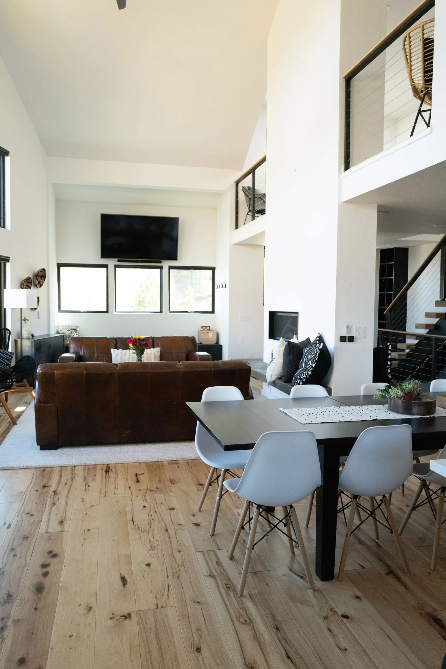 Bright living room with a gray sofa, white dining chairs and hardwood floors in Hot Sulphur Springs, Colorado