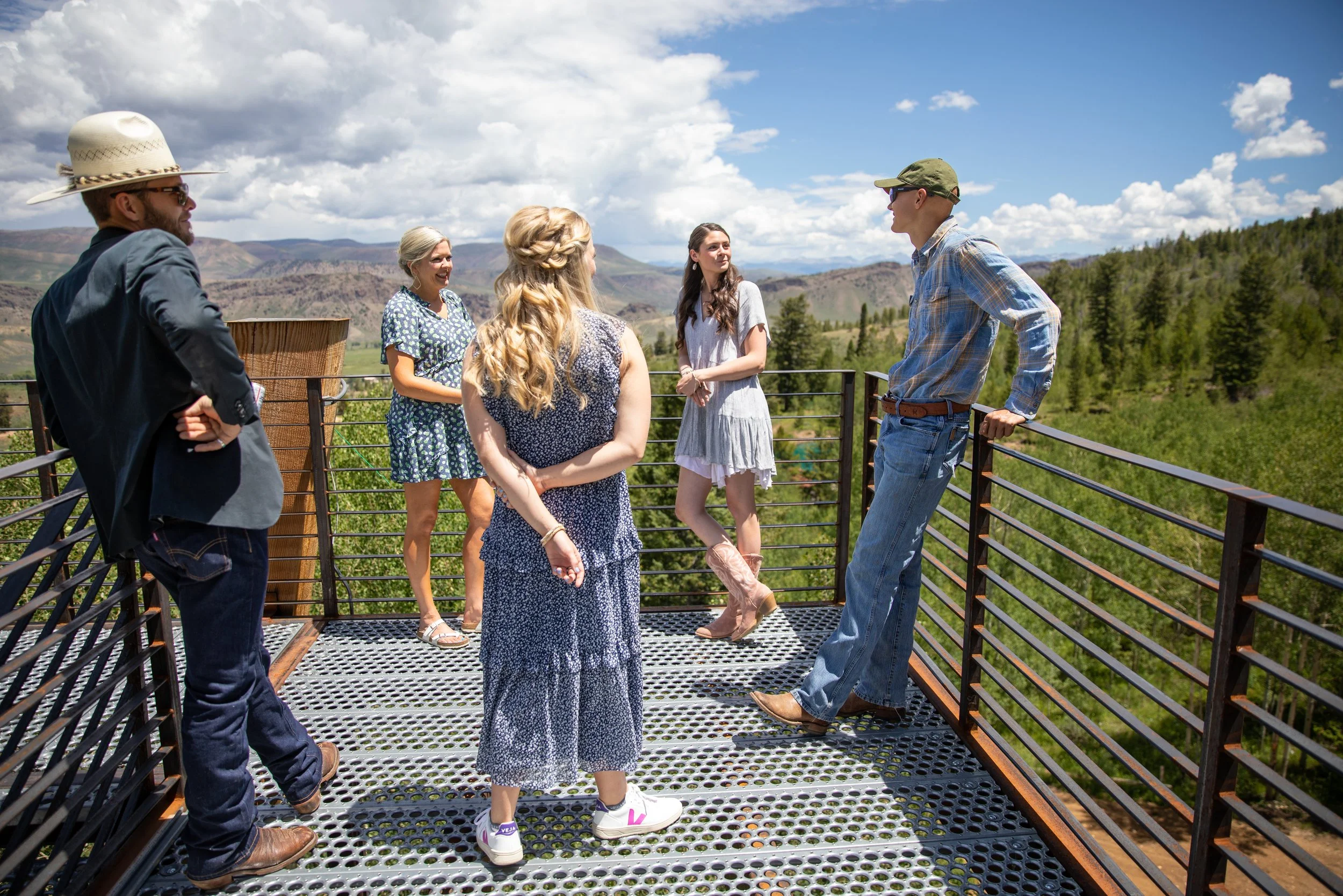 Group of friends and family on a metal-grate overlook with mountain views in Hot Sulphur Springs, Colorado