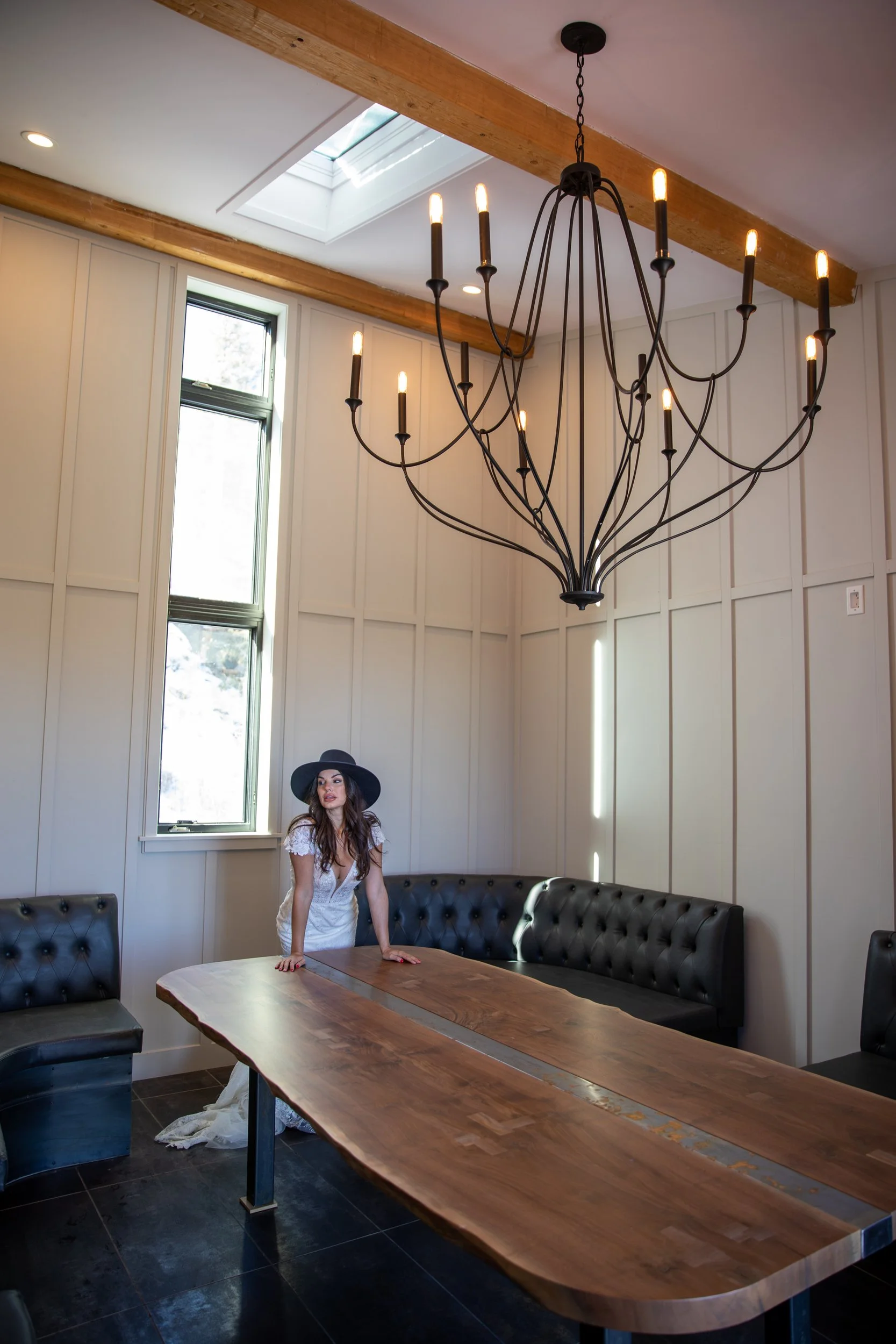 Cabin dining room with a chandelier and a long wood table at Tundra Springs, Colorado mountain wedding venue