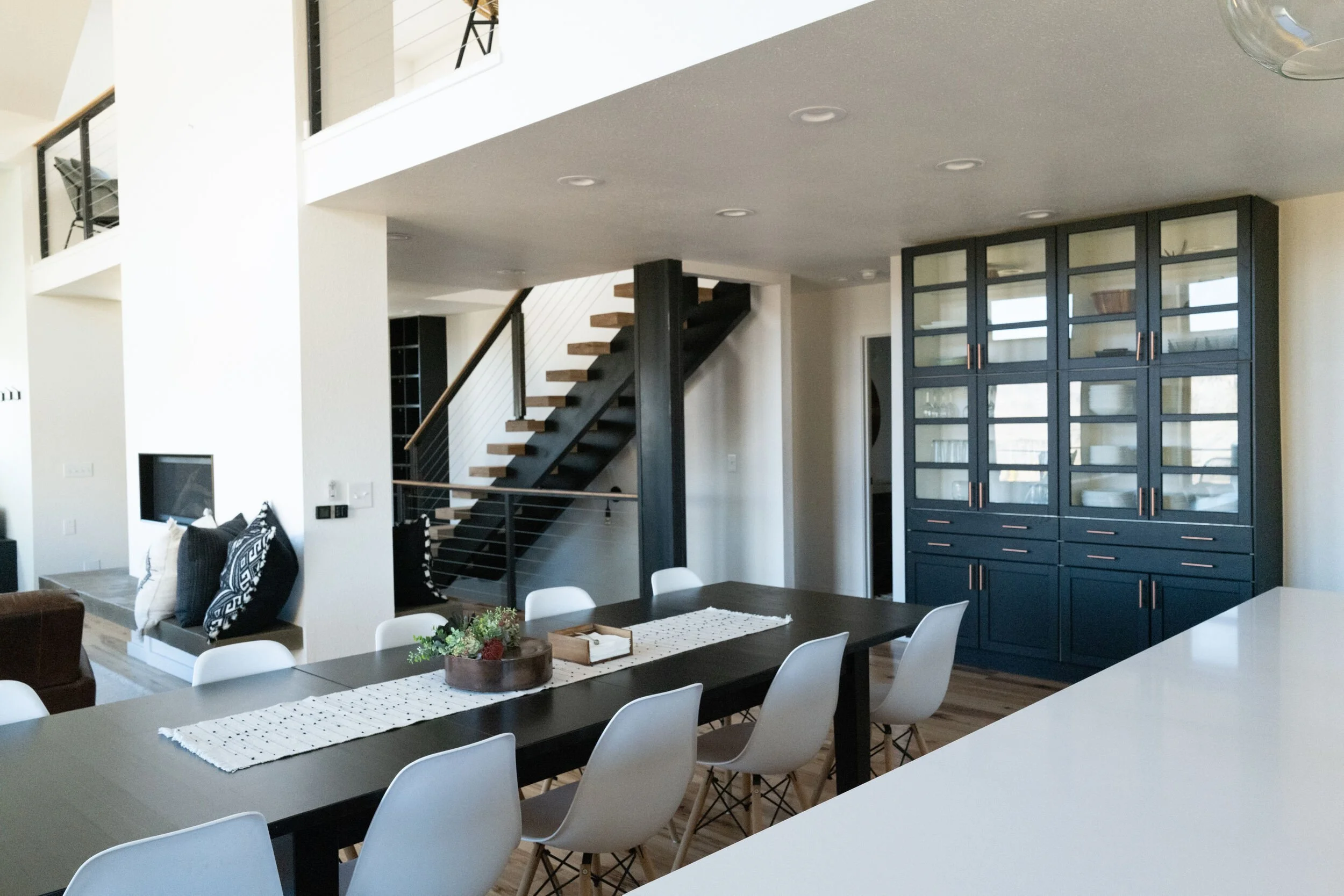 Open-plan great room with a staircase, dining table and black-framed glass doors in Hot Sulphur Springs, Colorado