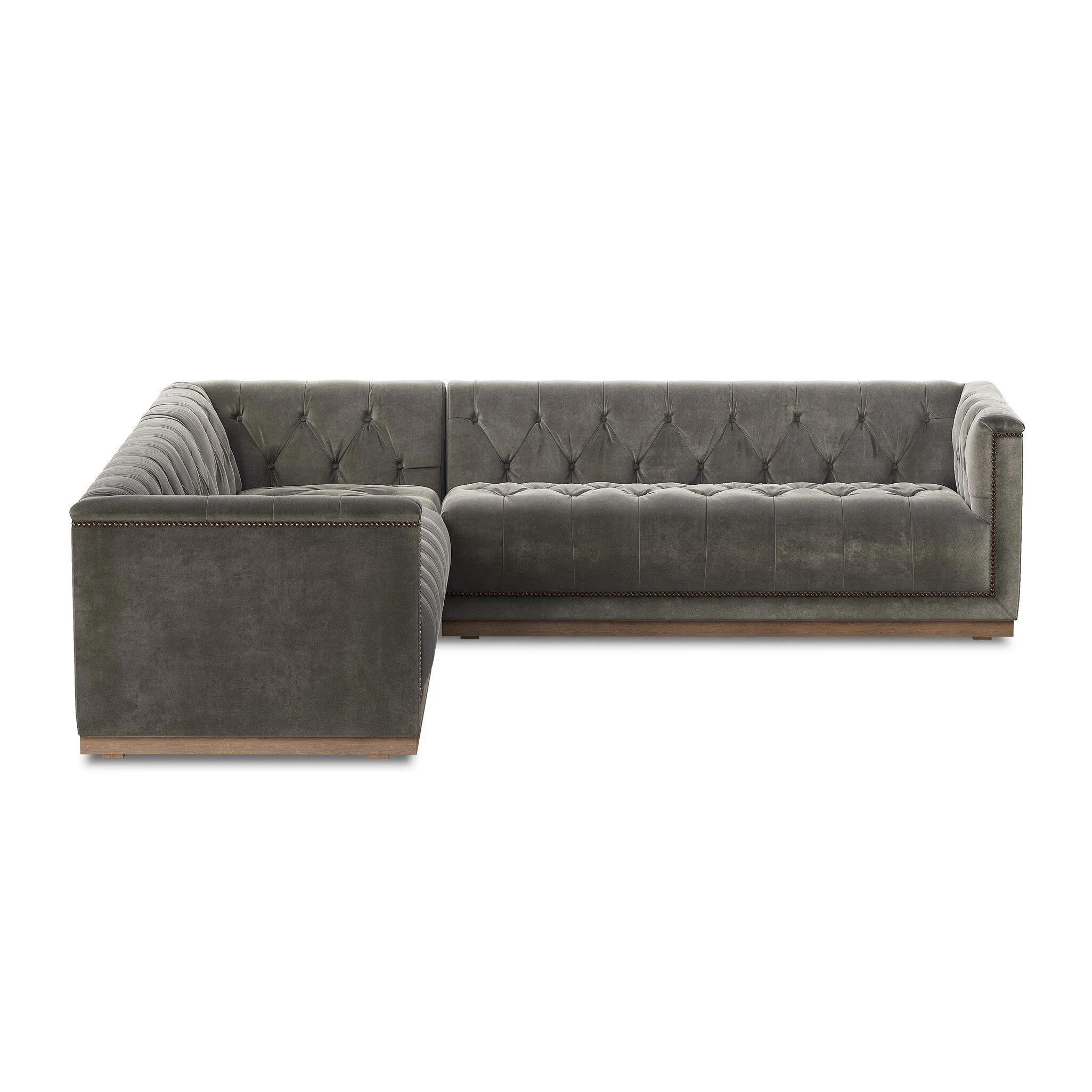 Gray velvet L-shaped sectional sofa with tufted cushions, rolled arms, nailhead trim, and wooden base on a white background