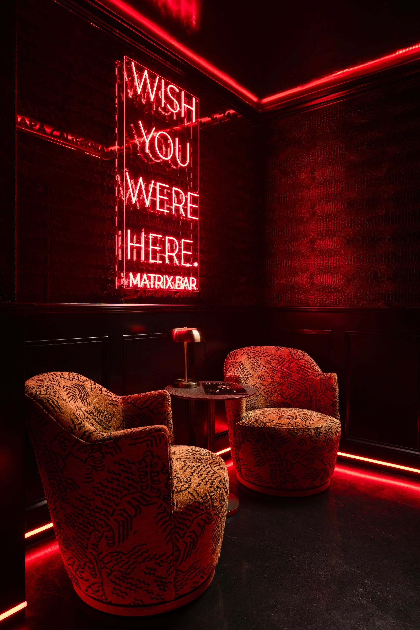 Red neon-lit lounge nook with velvet armchairs and a neon sign, Matrix Bar, Napa
